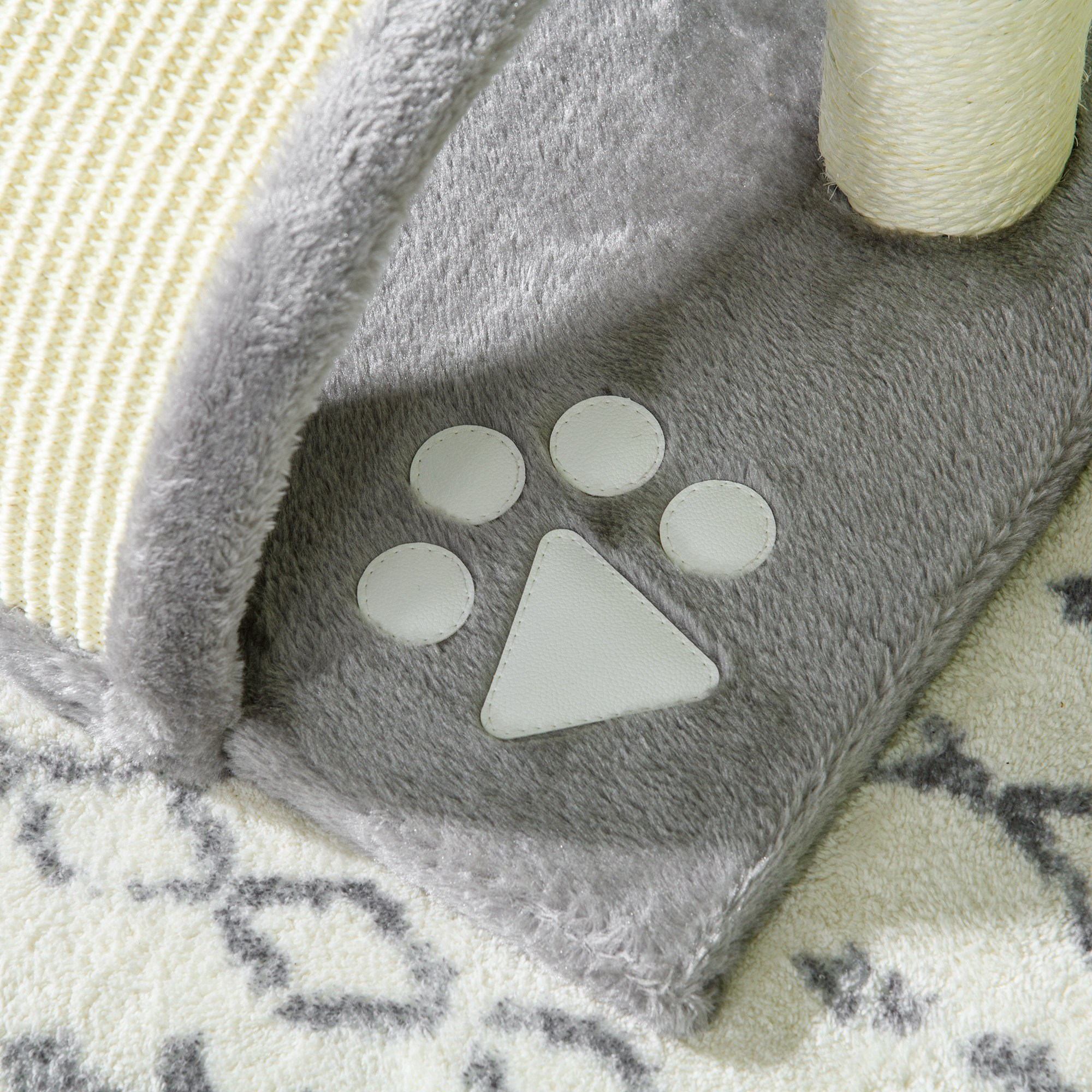 Primer plano de un rascador para gatos. Un detalle en forma de pata es visible en la base.