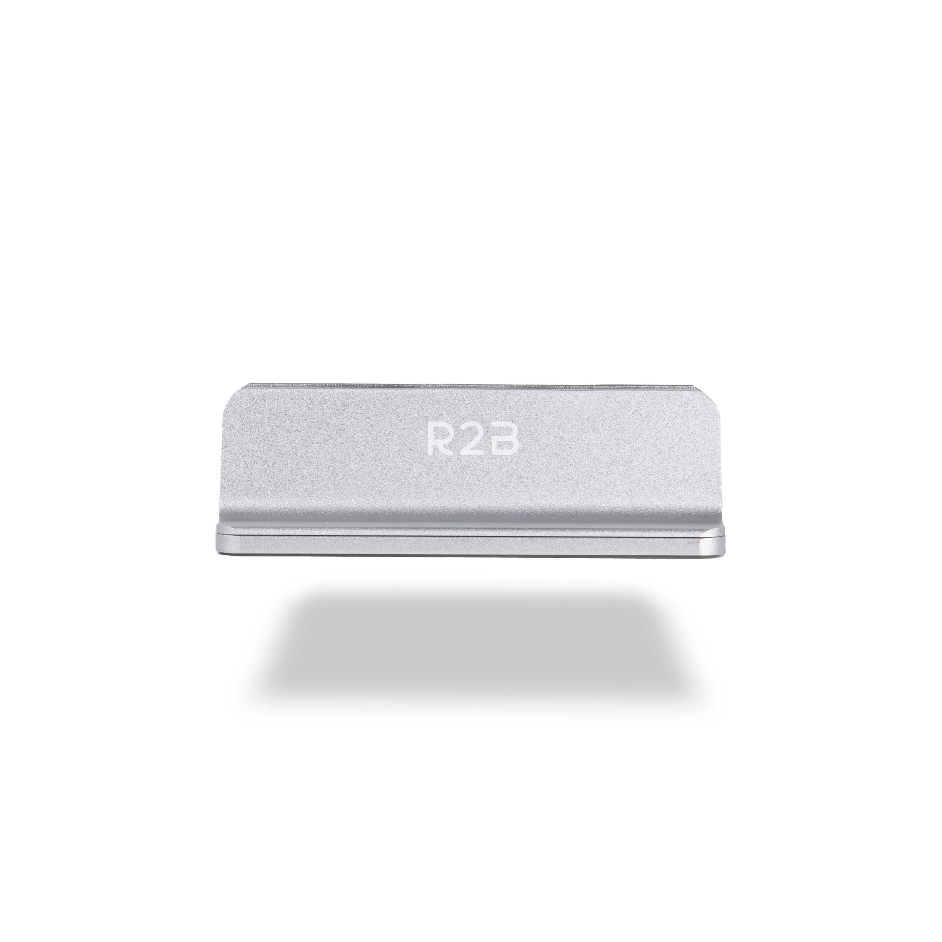 Een zilveren metalen blok met 'R2B' gegraveerd, dat een schaduw op wit werpt.