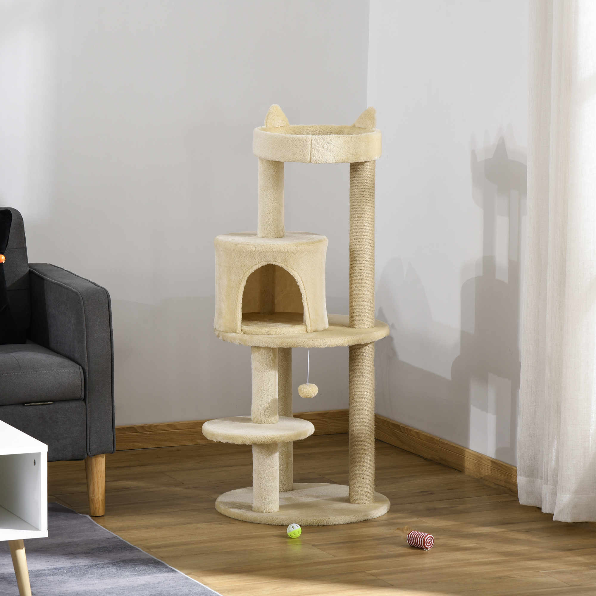 Un árbol para gatos beige alto con múltiples plataformas, una casa para gatos y un juguete colgante.