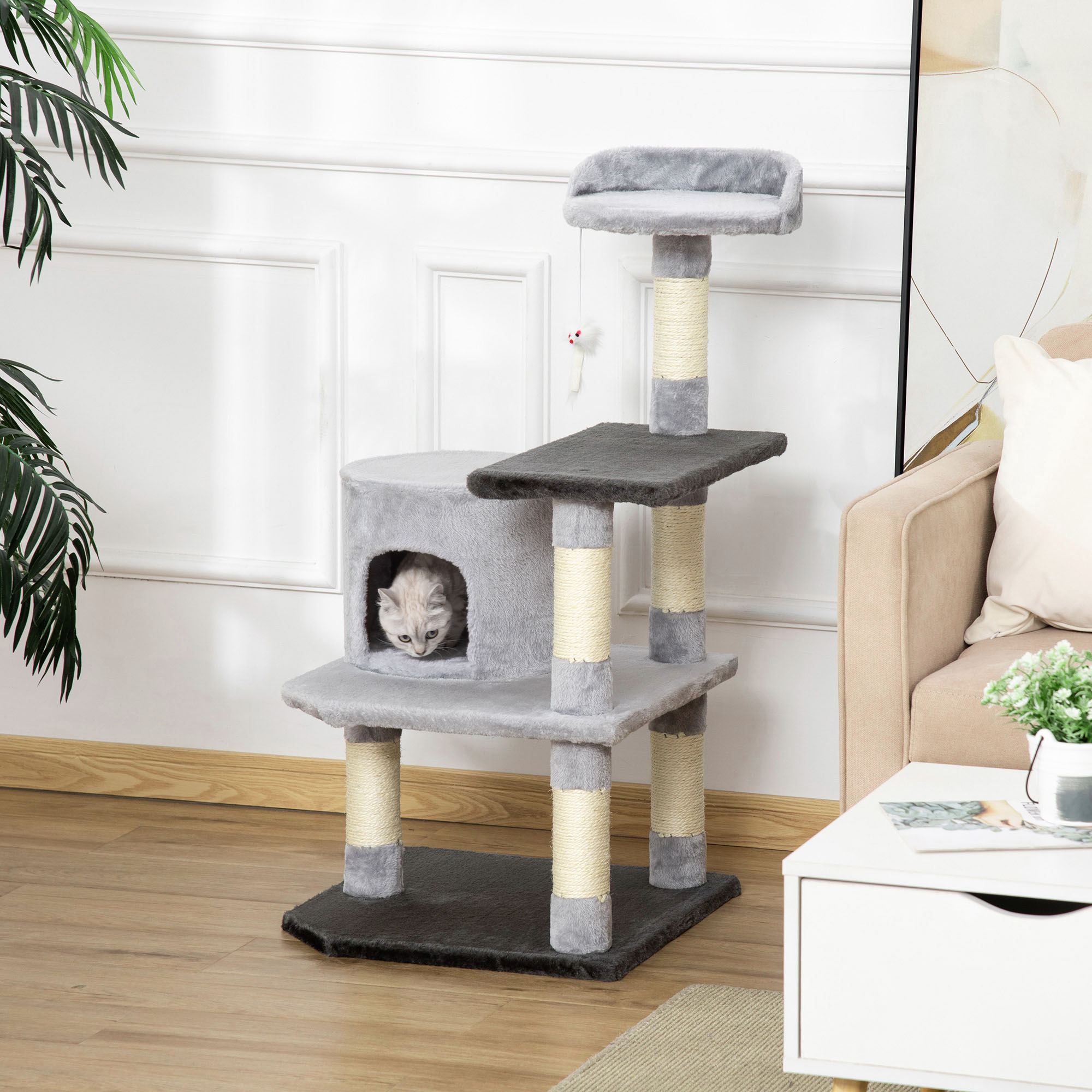 Árbol para gatos gris con gato en cueva y arriba, en entorno doméstico.