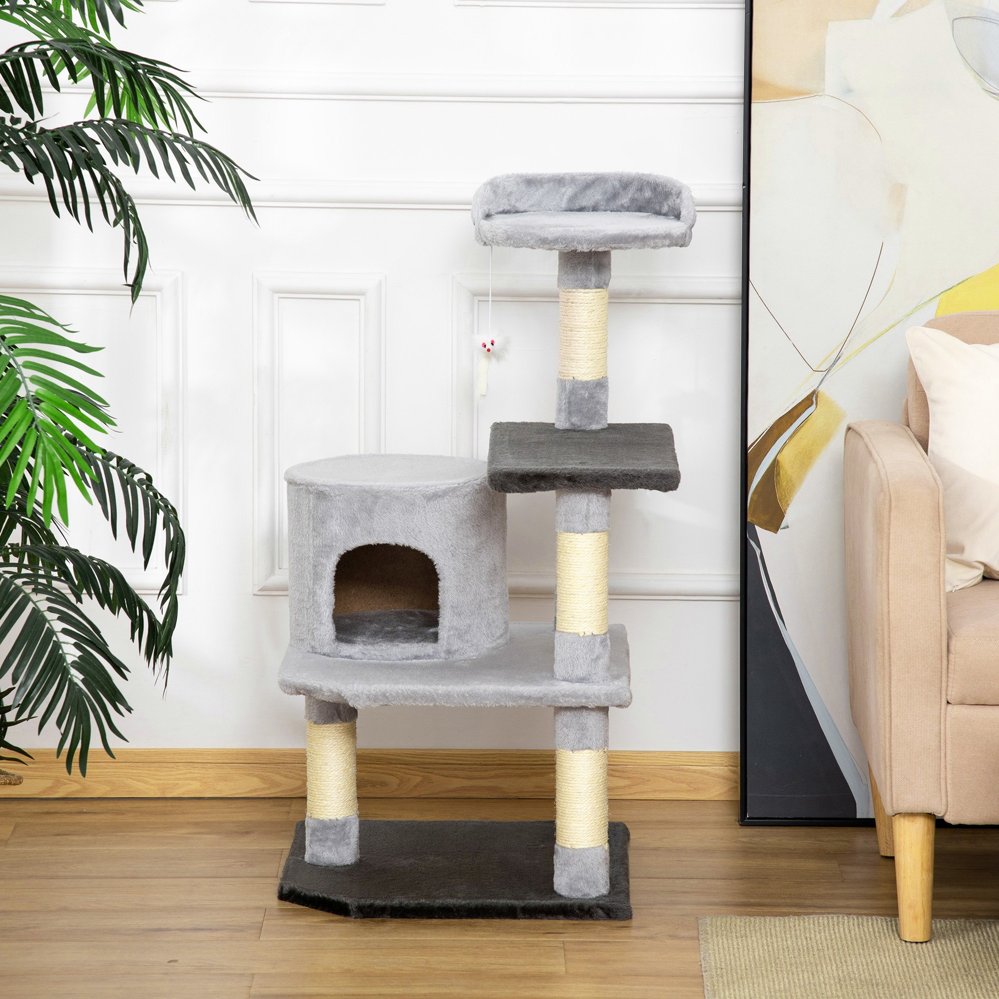 Un árbol para gatos gris con múltiples niveles, una casa para gatos y juguetes colgantes; un fondo neutral.