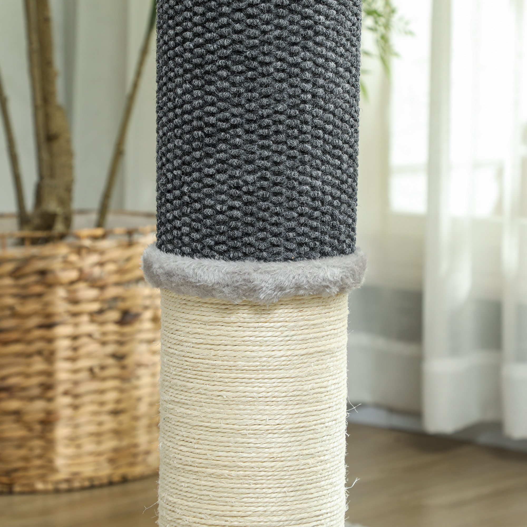 Primer plano de un poste rascador para gatos. Tiene tela de punto gris sobre una base de cuerda marrón. El poste es vertical.