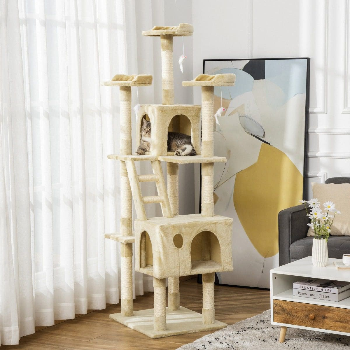 Un gran árbol para gatos con múltiples niveles y dos gatos. Color beige, un cuadro en la pared.