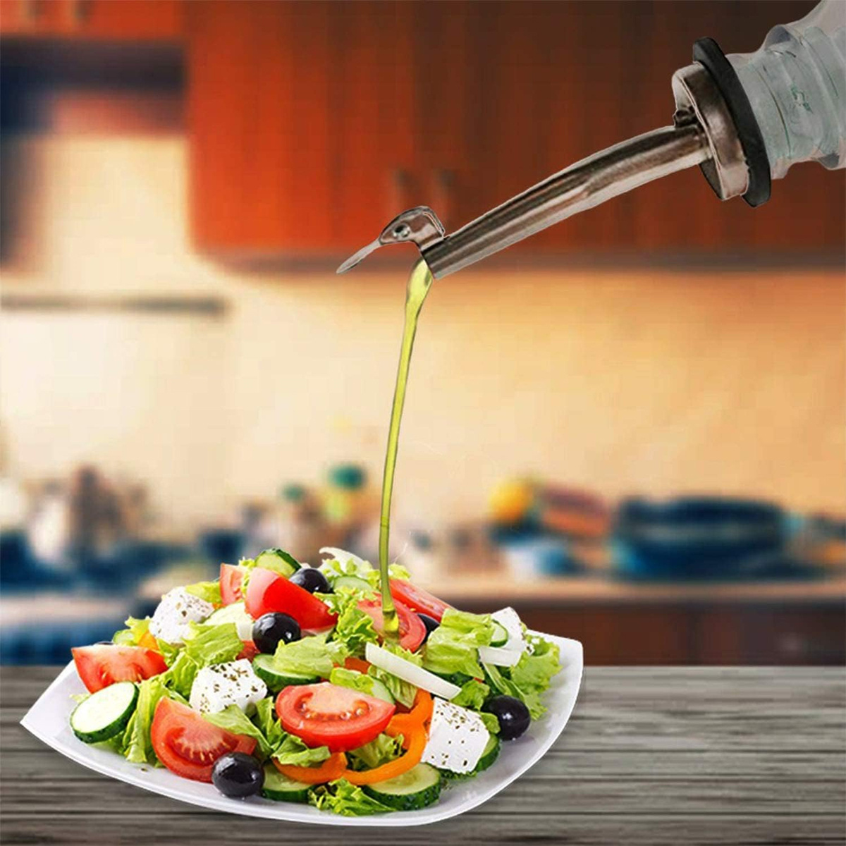 Salat mit Tomaten, Oliven und Käse. Olivenöl wird darüber gegossen. Weißer Teller.