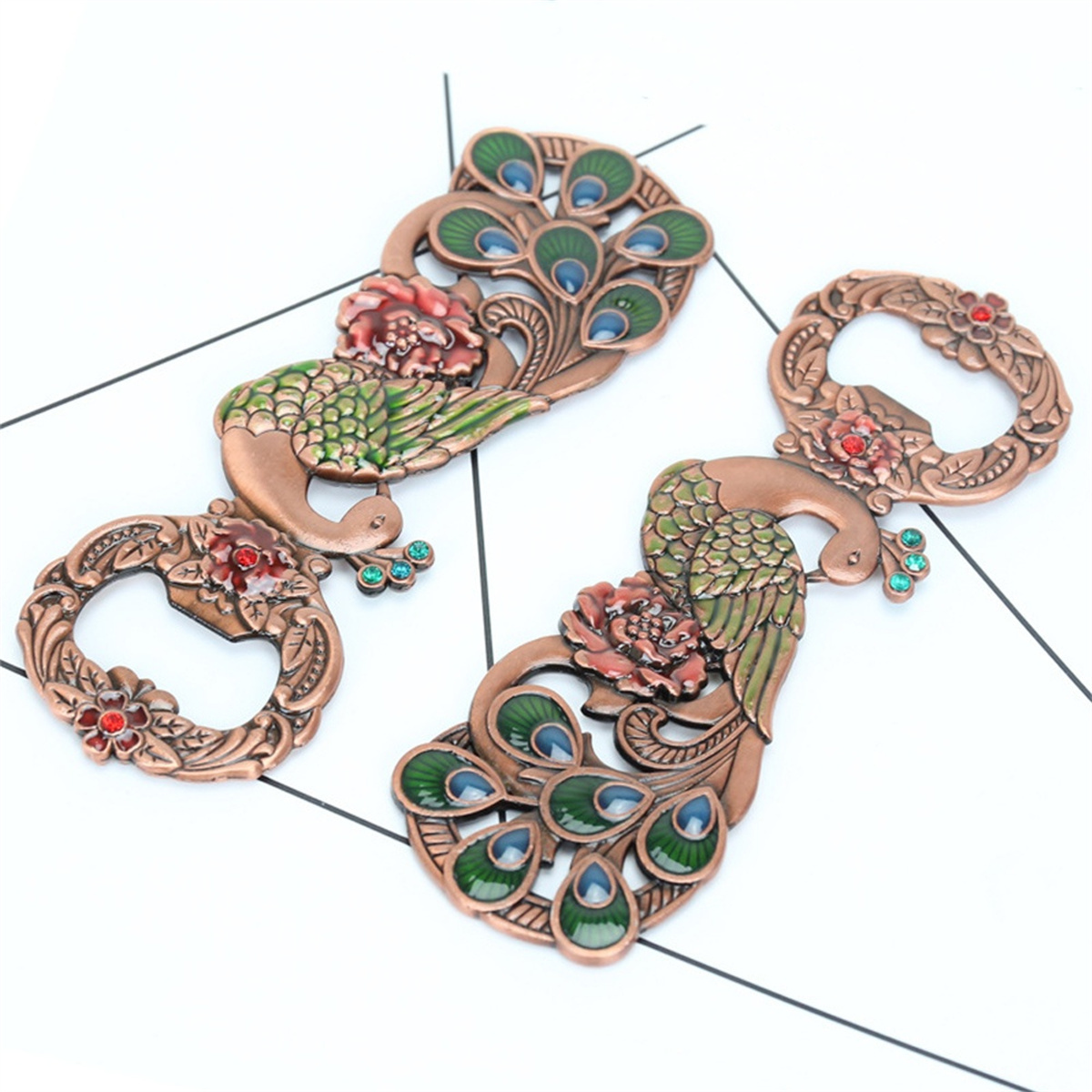 Drei verzierte Pfauendekorationen. Bronzefarben mit Blumen- und Juwelenakzenten. Weißer Hintergrund.
