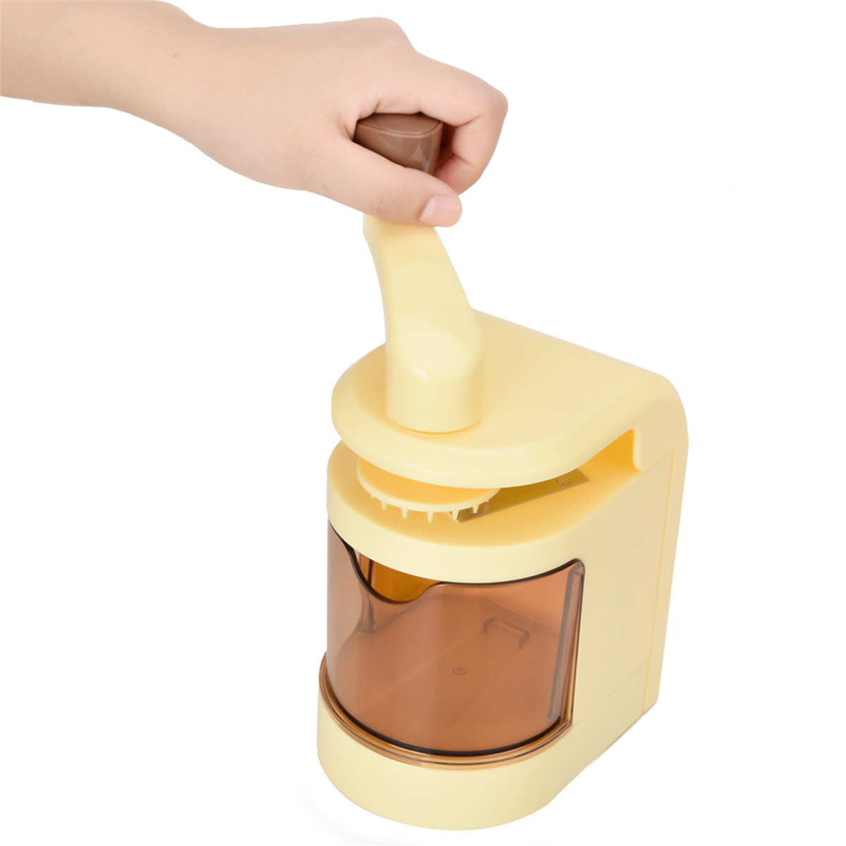 Hand dreht eine Kurbel an einem Küchenwerkzeug. Beige- und Brauntöne. Weißer Hintergrund.