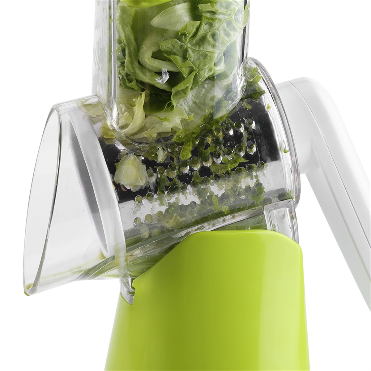 Ein grüner und weißer Gemüseschneider. Er ist mit geschnittenem Salat gefüllt.