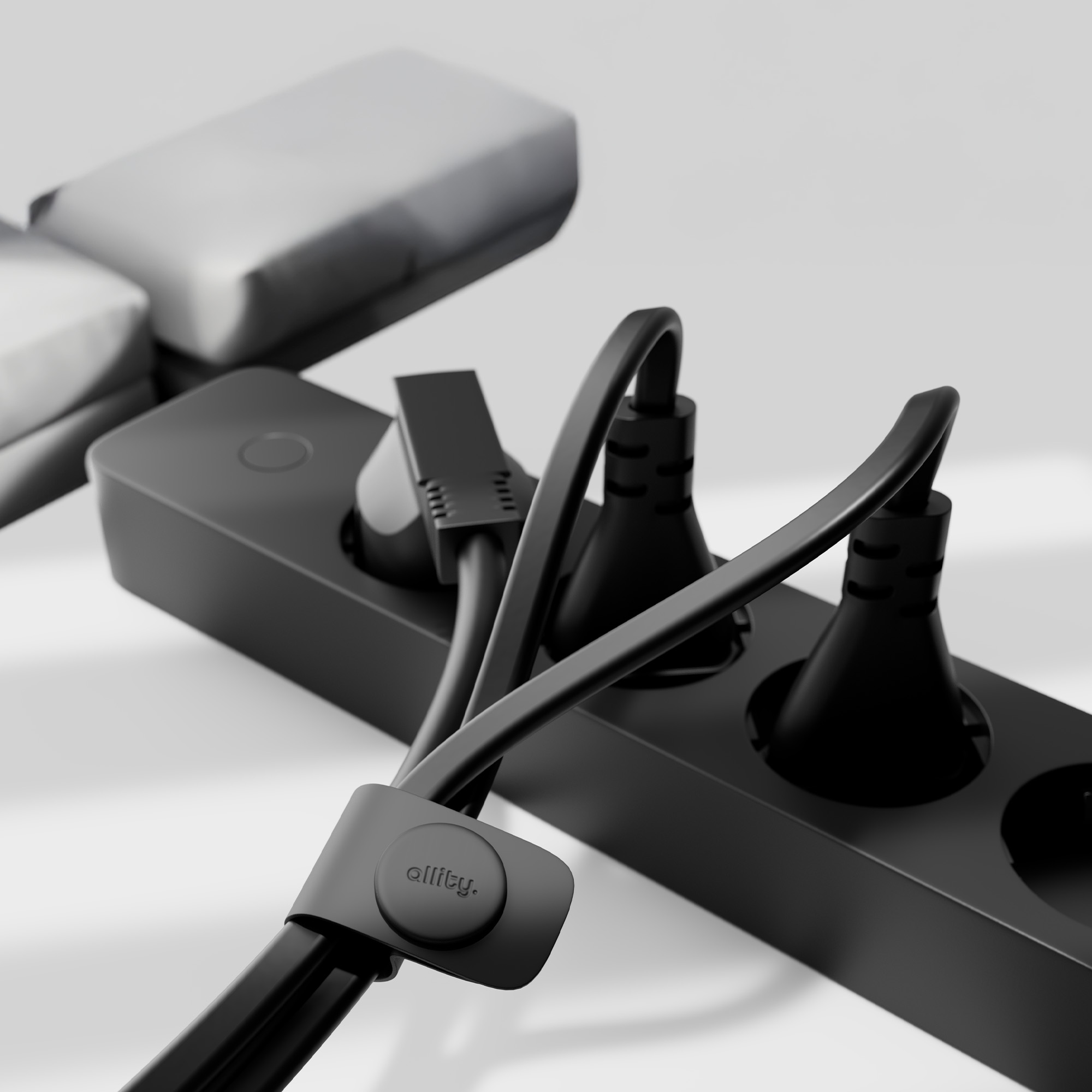 Czarny przedłużacz z trzema gniazdami, organizerem kabli i przewodem zasilającym, wszystko w zbliżeniu.