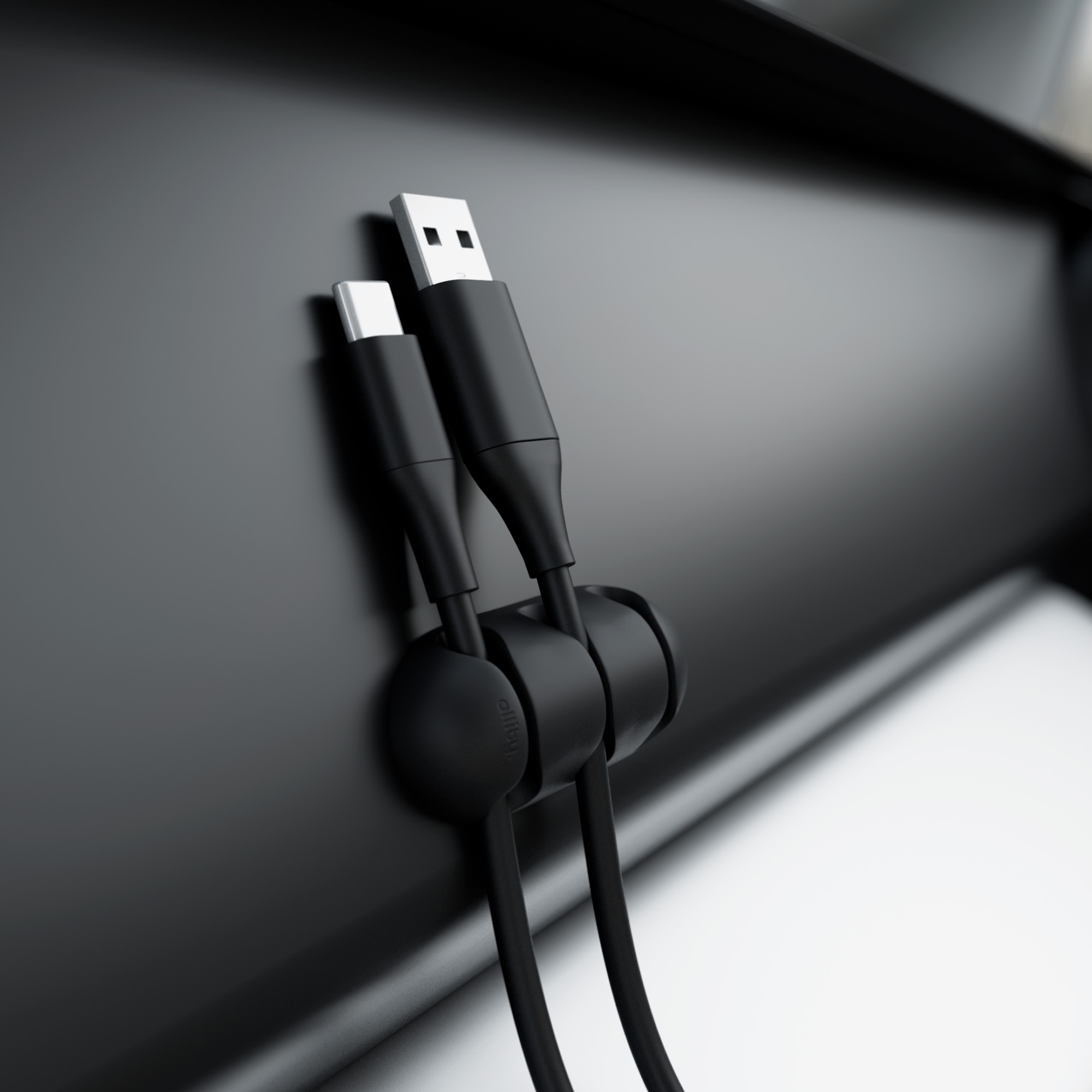 Czarne kable USB i USB-C w czarnym organizerze na czarnej powierzchni.