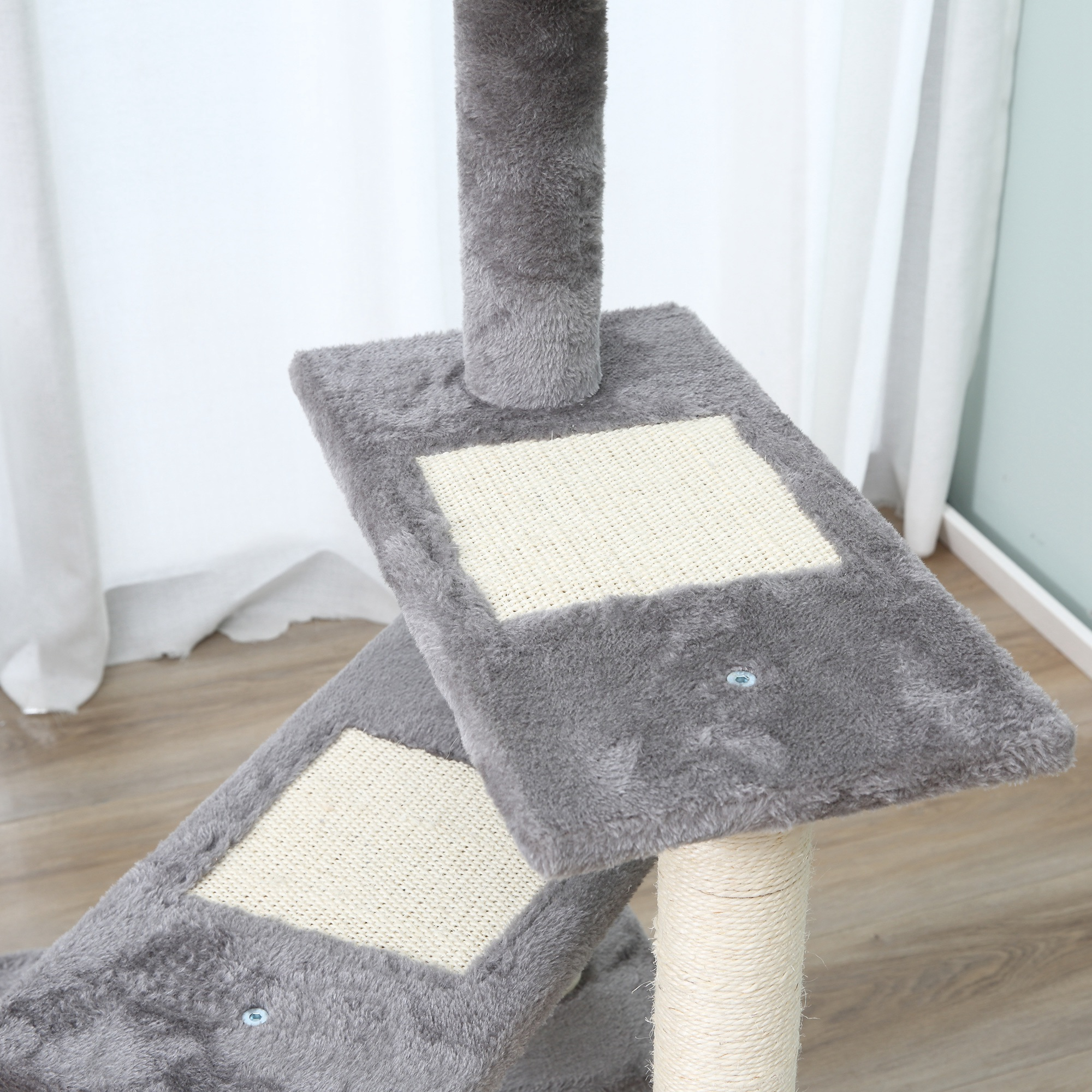 Detalle del árbol para gatos, mostrando una plataforma gris con superficie texturizada y un poste envuelto en sisal.