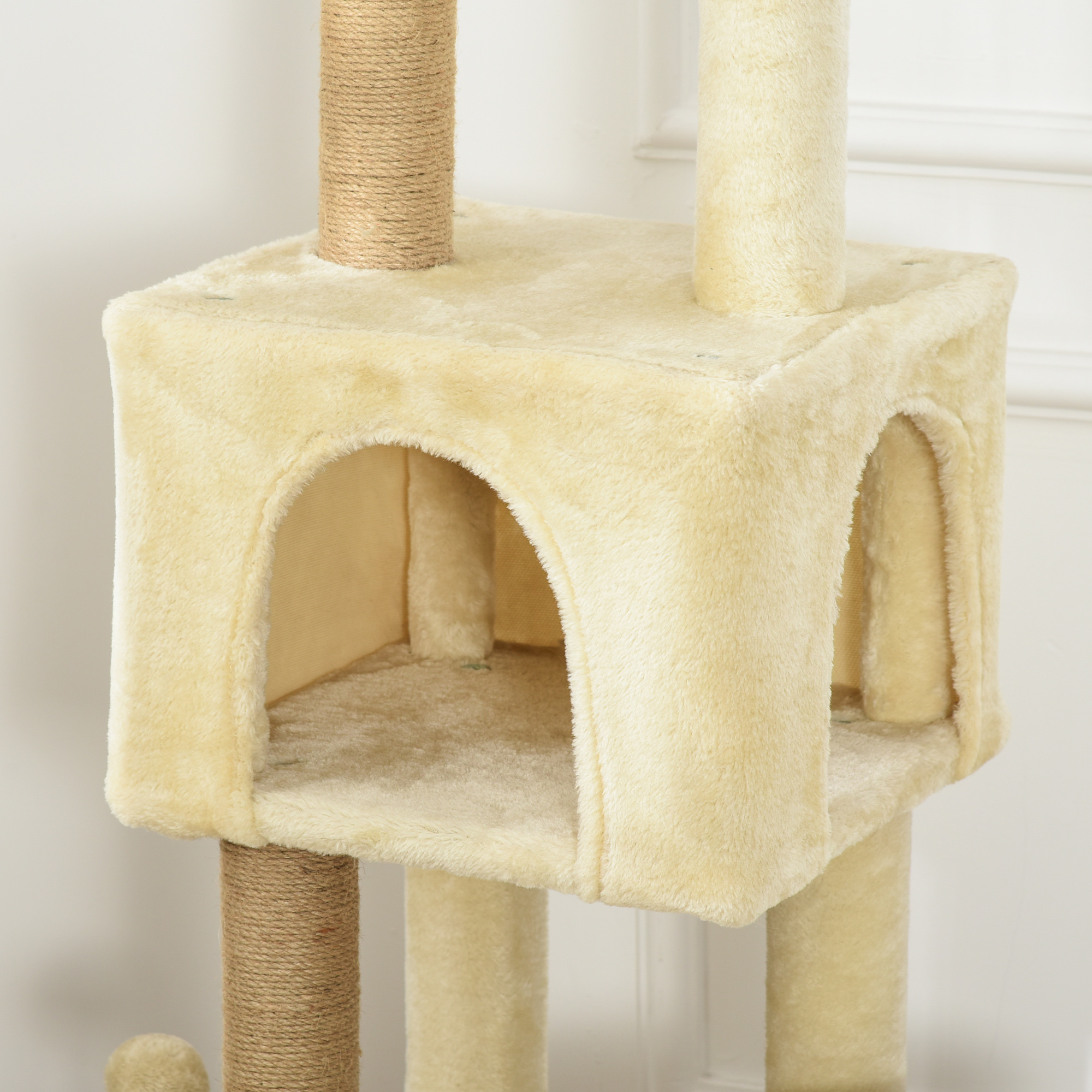Un árbol para gatos beige con múltiples aberturas. Tiene una superficie texturizada.