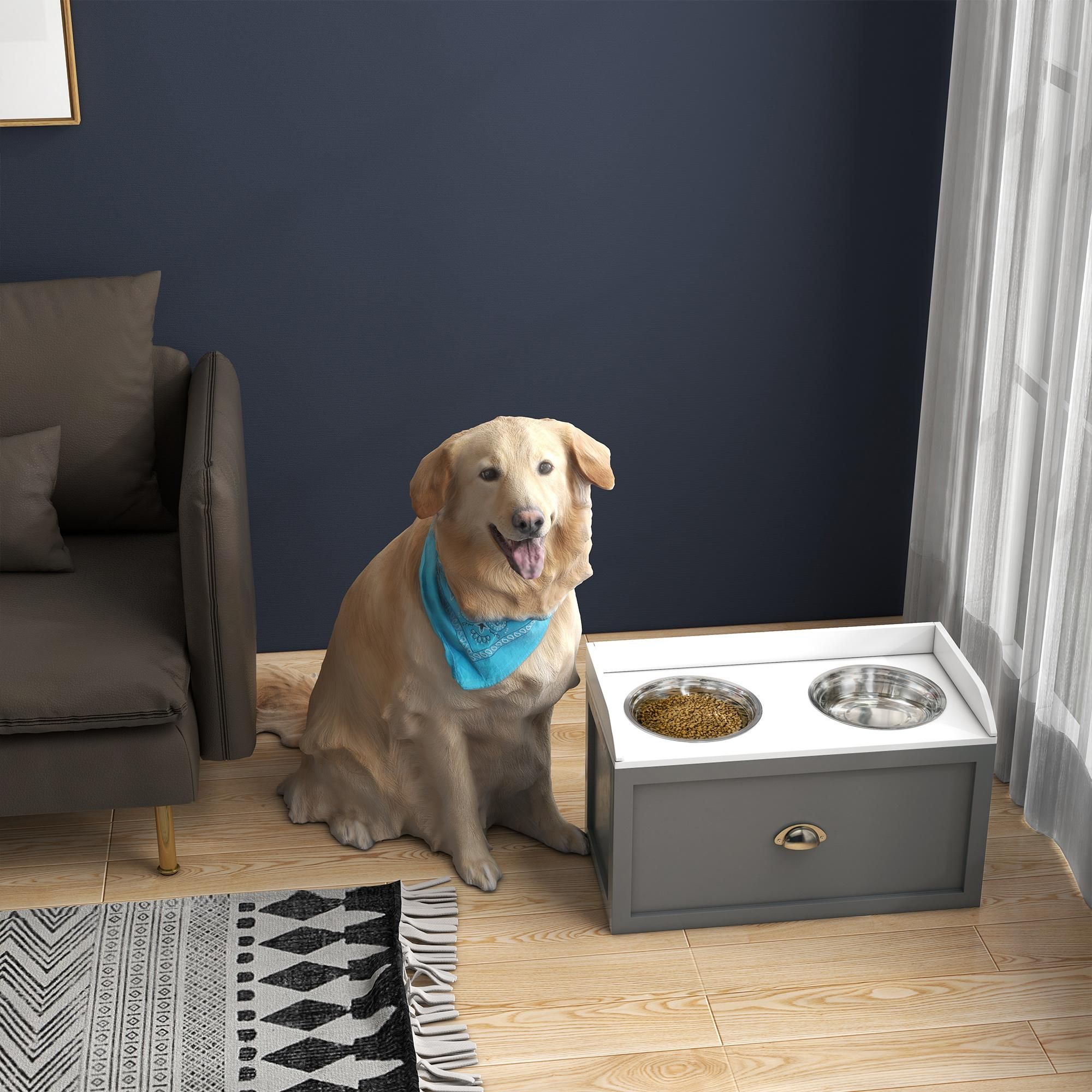 Golden Retriever con pañuelo azul sentado cerca de un armario gris para comida de perros con dos cuencos.