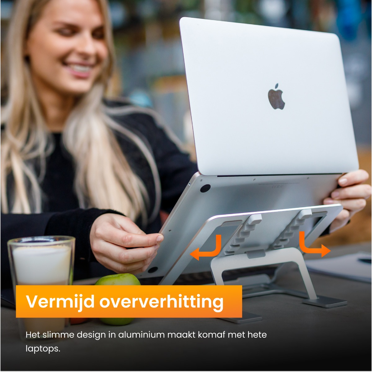 Een persoon die een laptop op een standaard gebruikt. Pijlen geven de luchtstroom aan. De tekst zegt "Vermijd oververhitting".