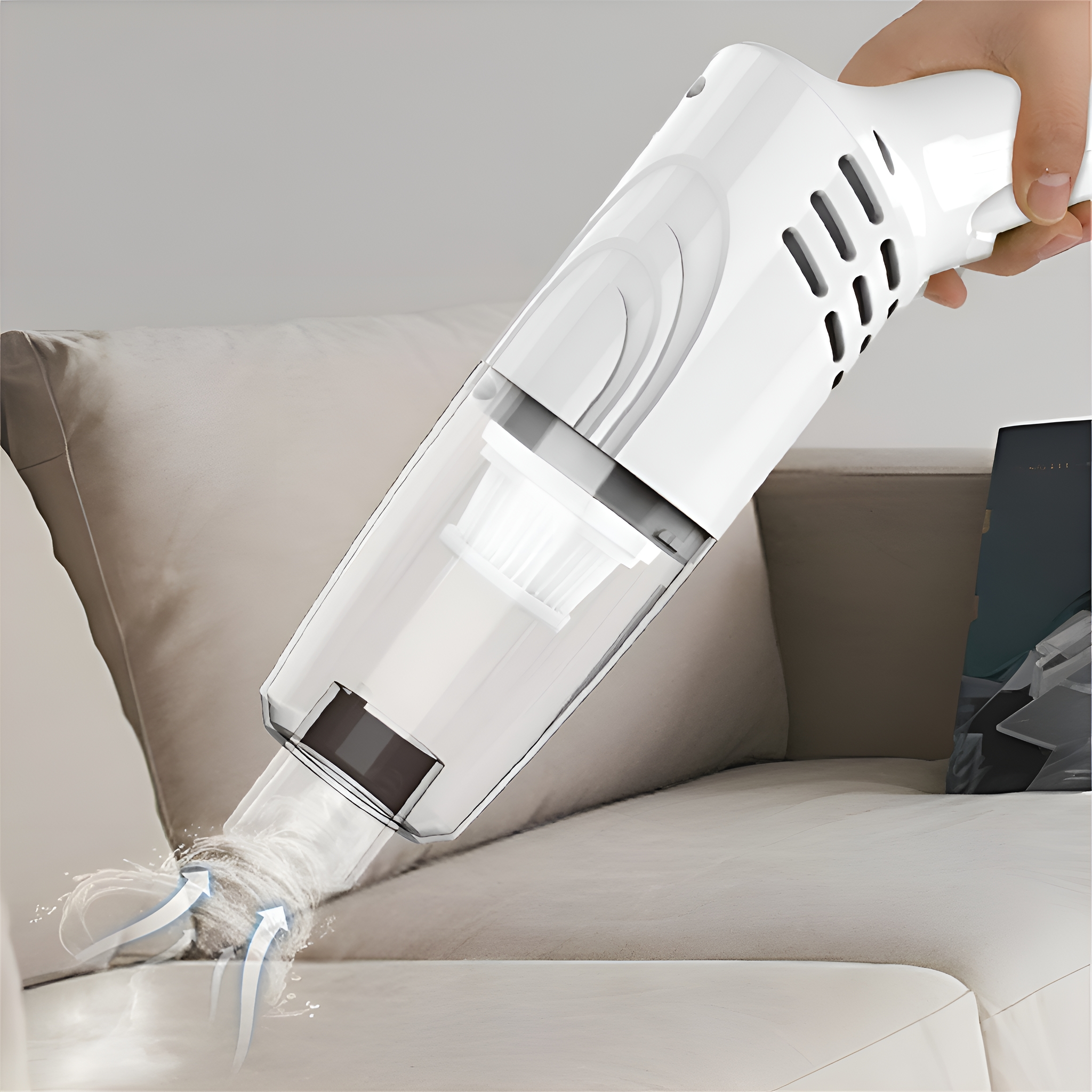 Eine Person benutzt einen weißen Staubsauger auf einem beigen Sofa.