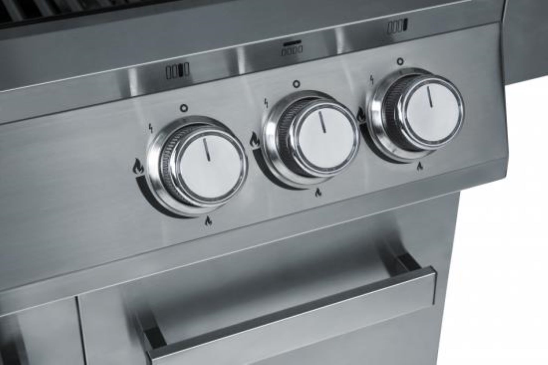 Nahaufnahme von drei silberfarbenen Knöpfen an einem Edelstahlgrill. Griffe.