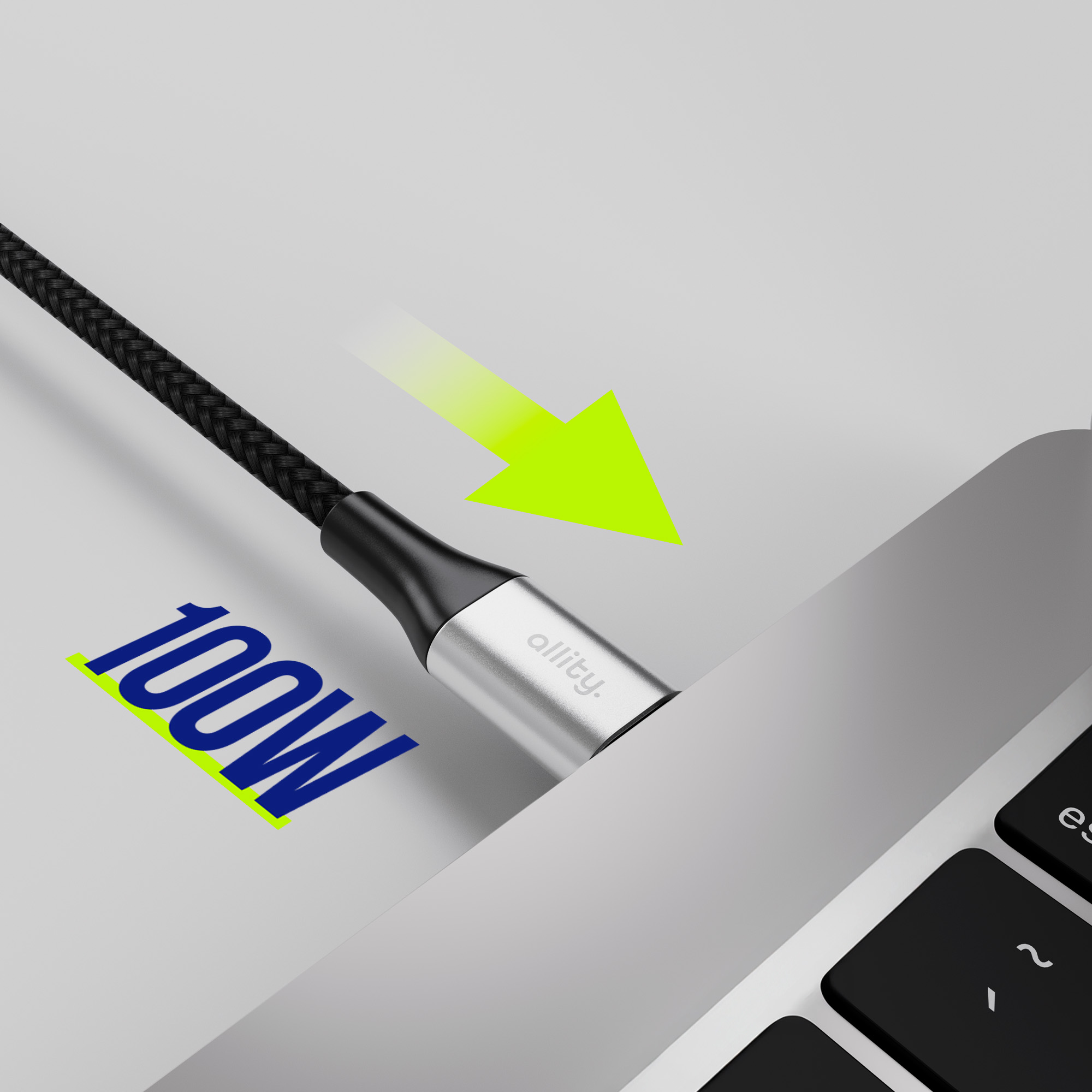 Czarny pleciony kabel podłączony do laptopa, z tekstem 100W i zieloną strzałką.
