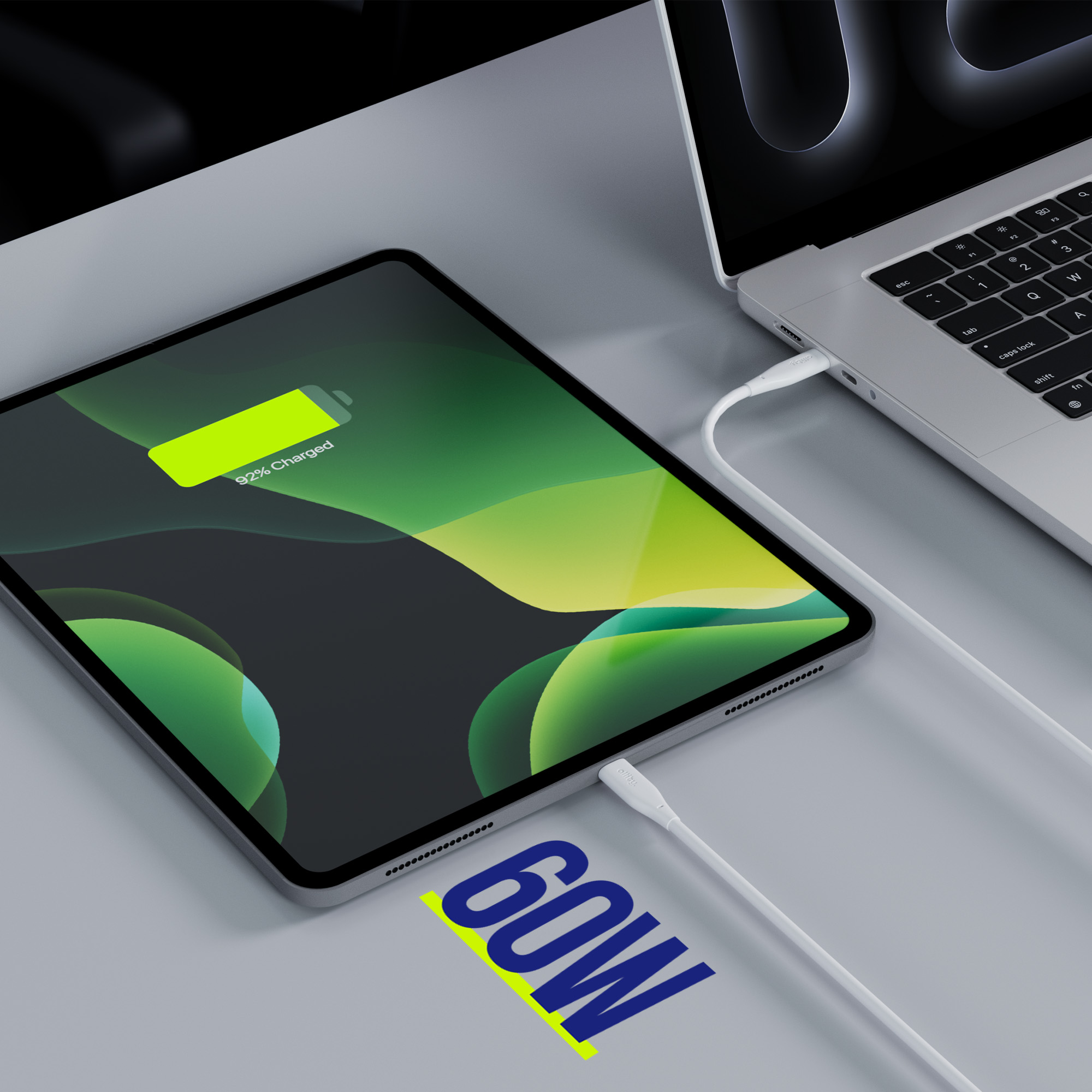 Tablet z naładowaniem 92%, podłączony do laptopa kablem USB-C. Etykieta 60W.
