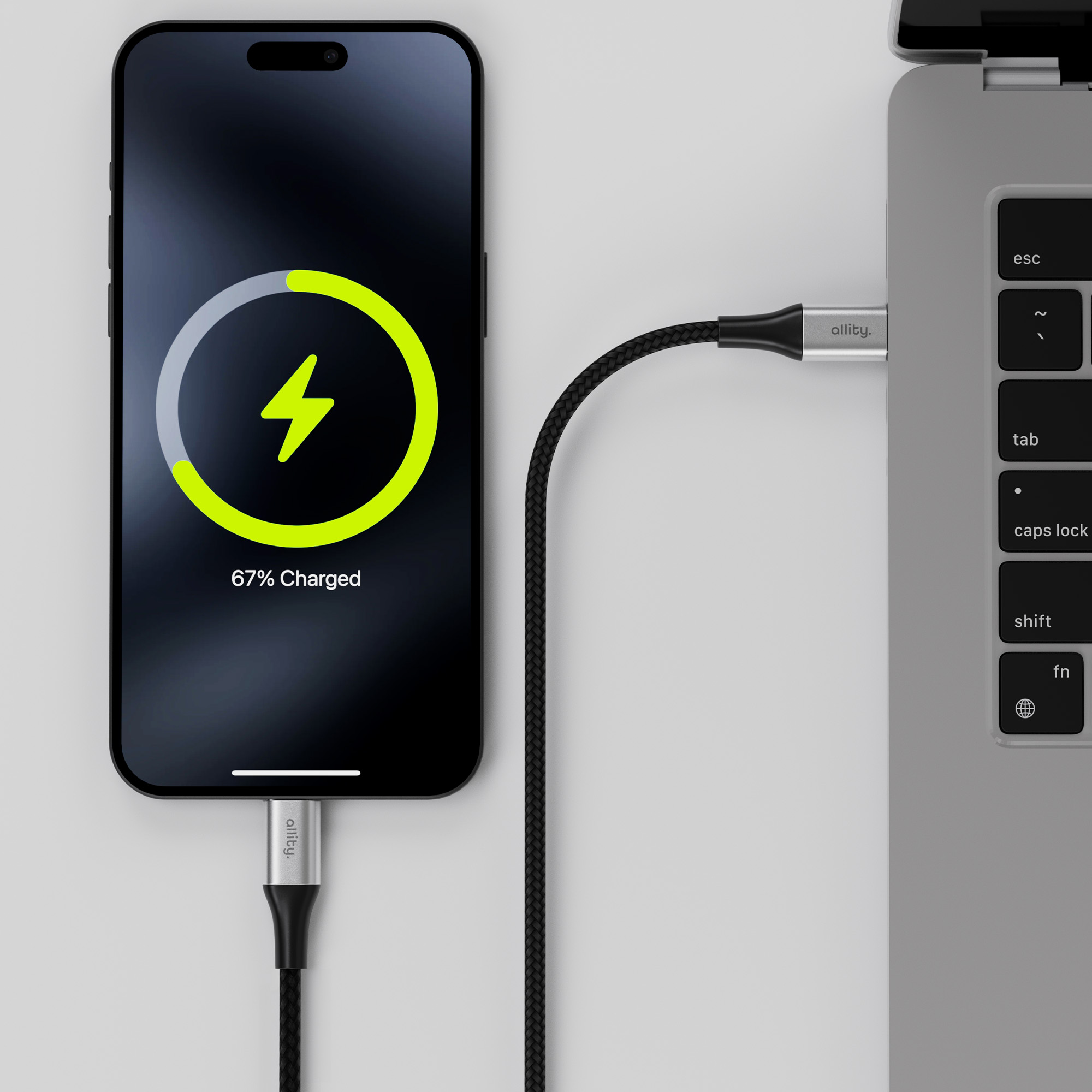 Smartfon ładujący się za pomocą kabla podłączonego do laptopa.