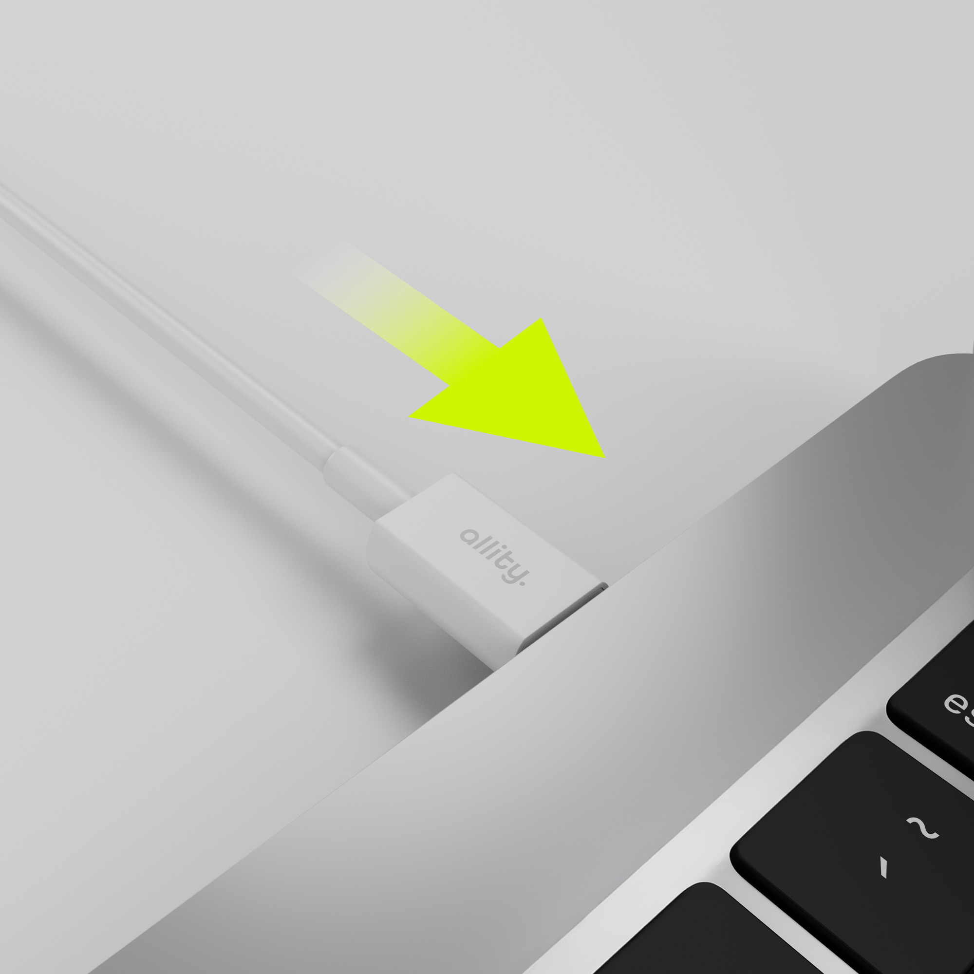 Biały kabel i złącze podłączone do laptopa. Żółta strzałka wskazuje połączenie.