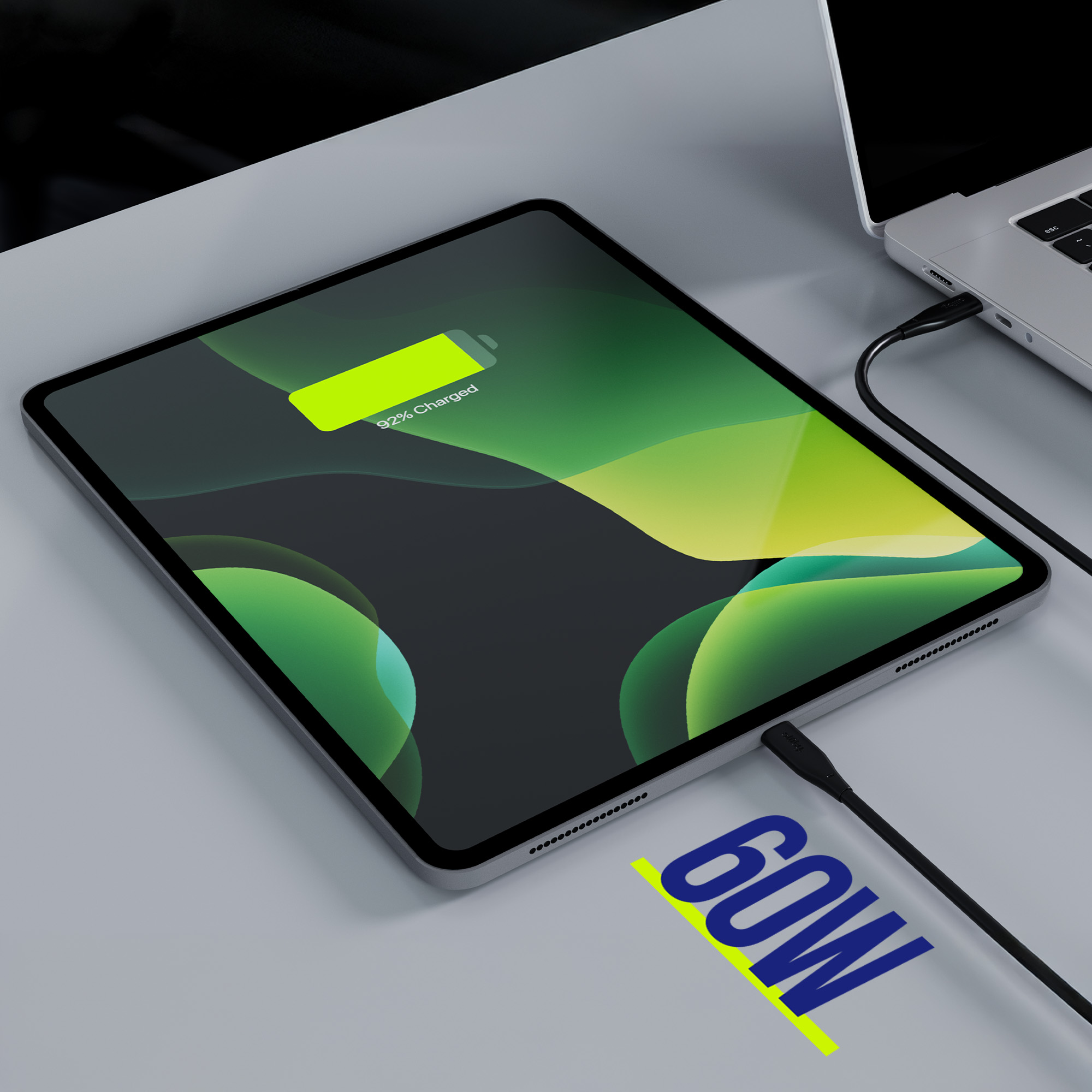 iPad ładujący się z podłączonym laptopem. iPad pokazuje 92% naładowania.