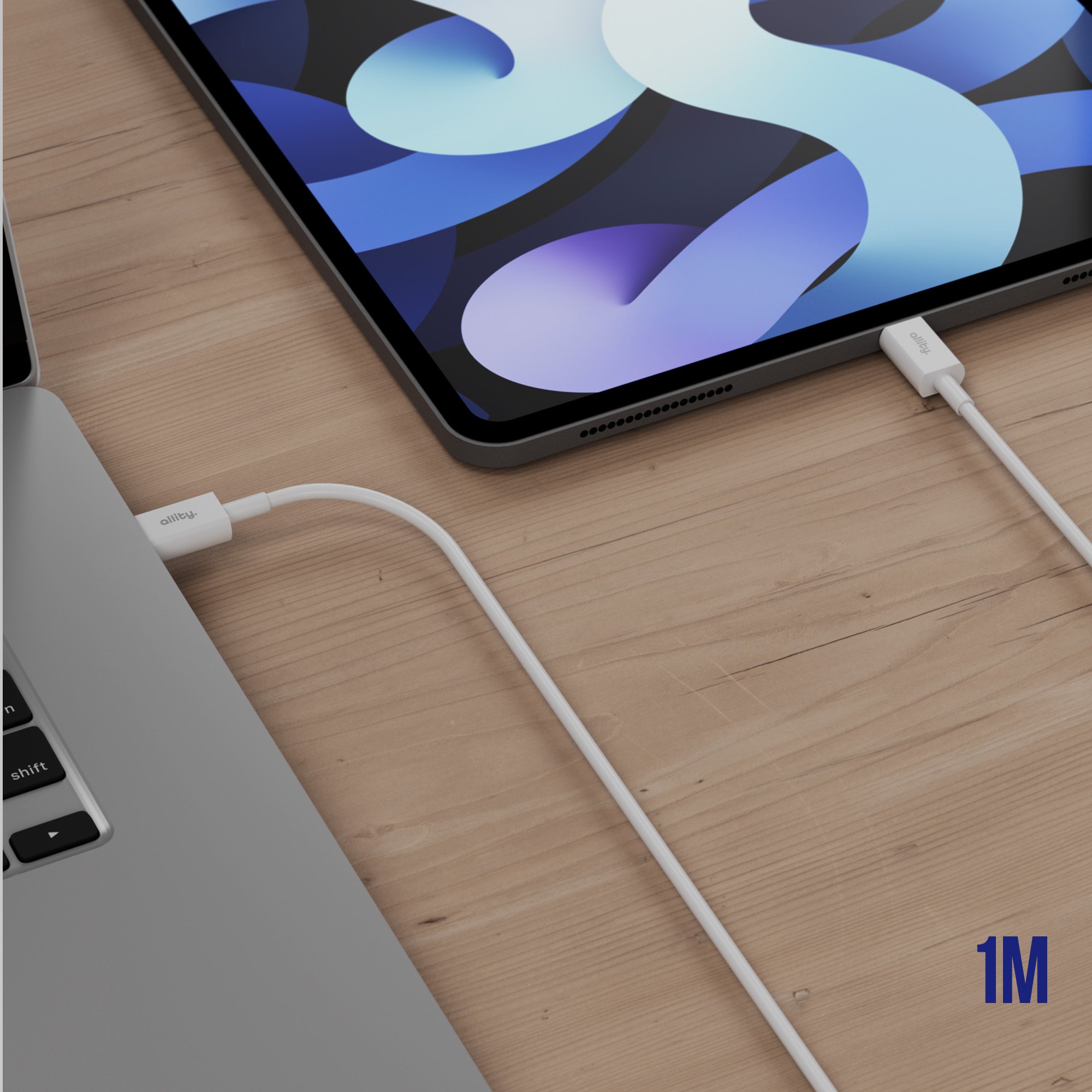 Laptop, kabel i tablet na drewnianej powierzchni. Kabel łączy tablet i laptop. Tekst: 1M.