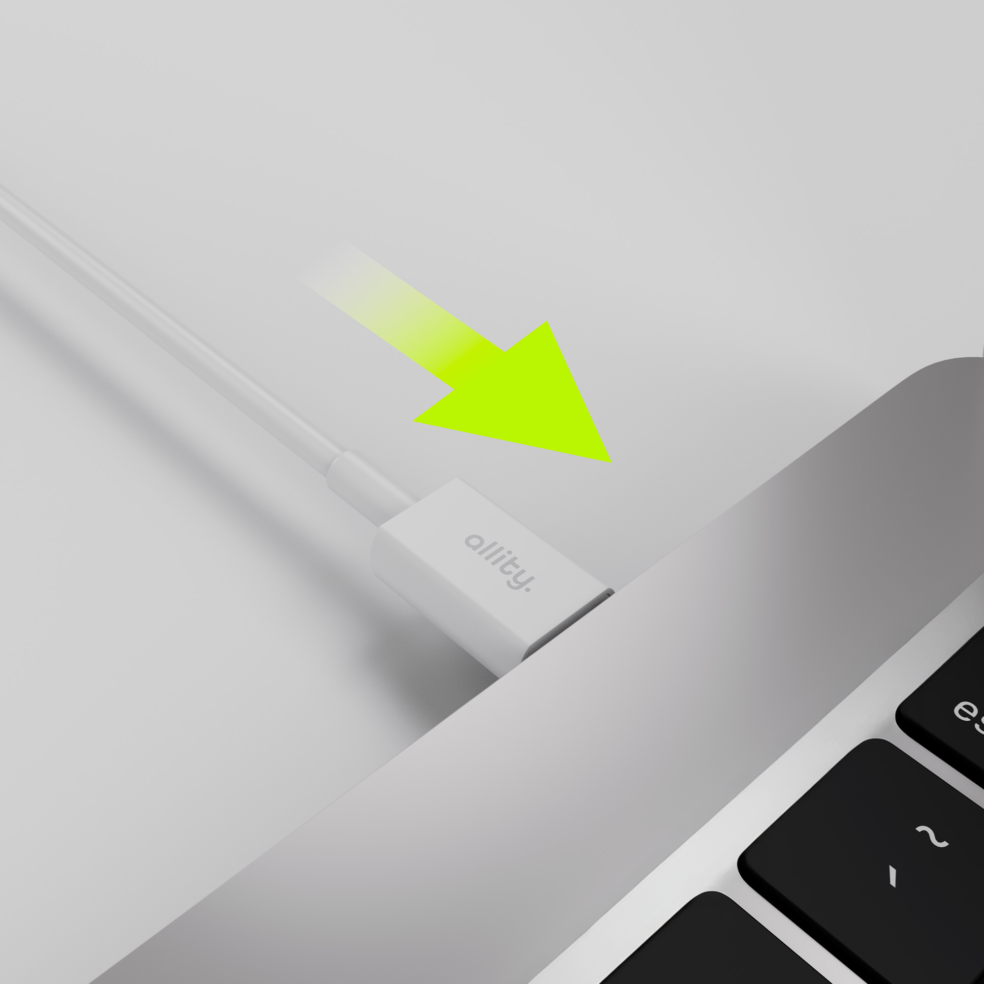 Biały kabel zasilający włożony do laptopa. Zielona strzałka wskazuje połączenie.