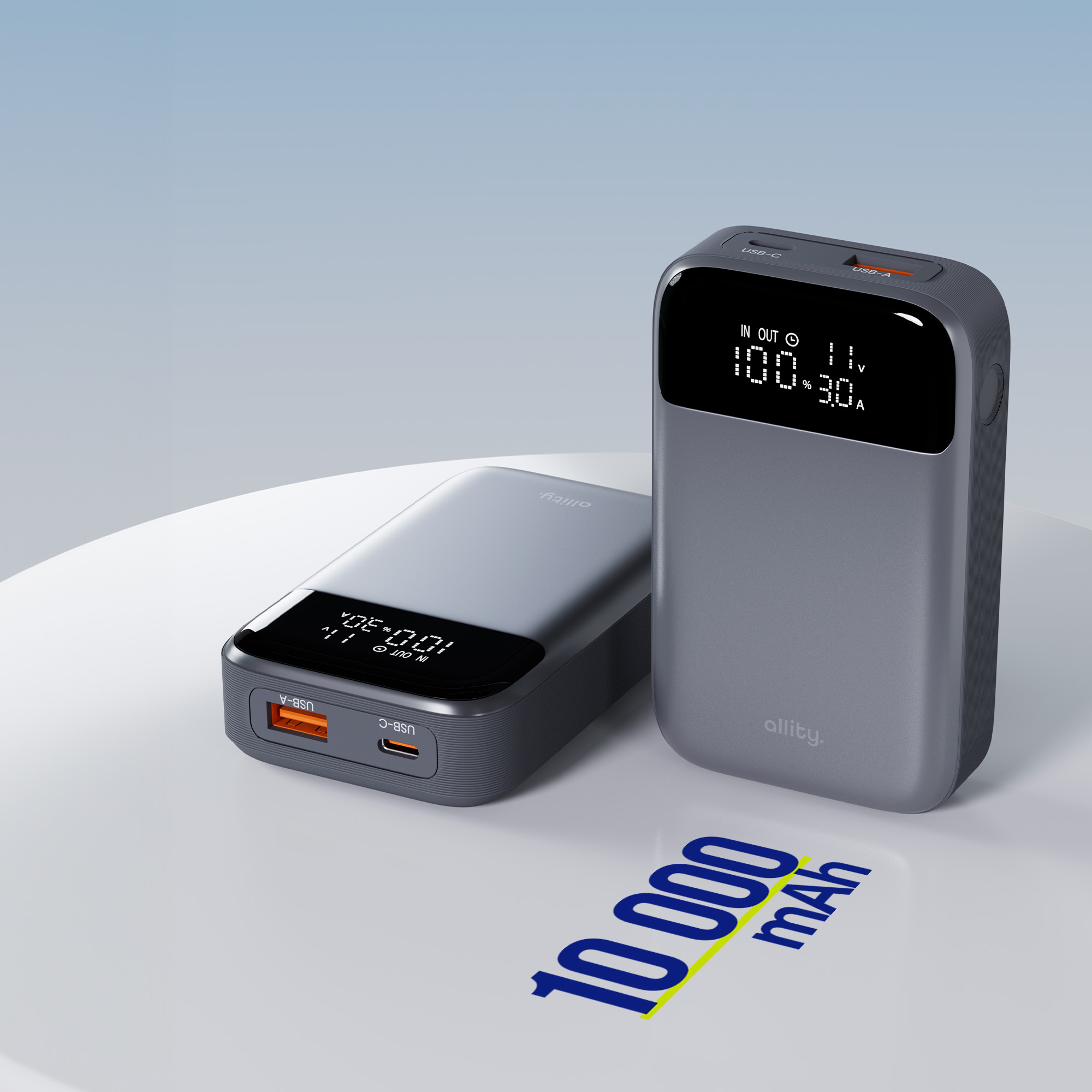 Dwa szare power banki z wyświetlaczami cyfrowymi. Jeden wyświetla '100.30', drugi '100.01'. Tekst na dole: '10 000 mAh'.