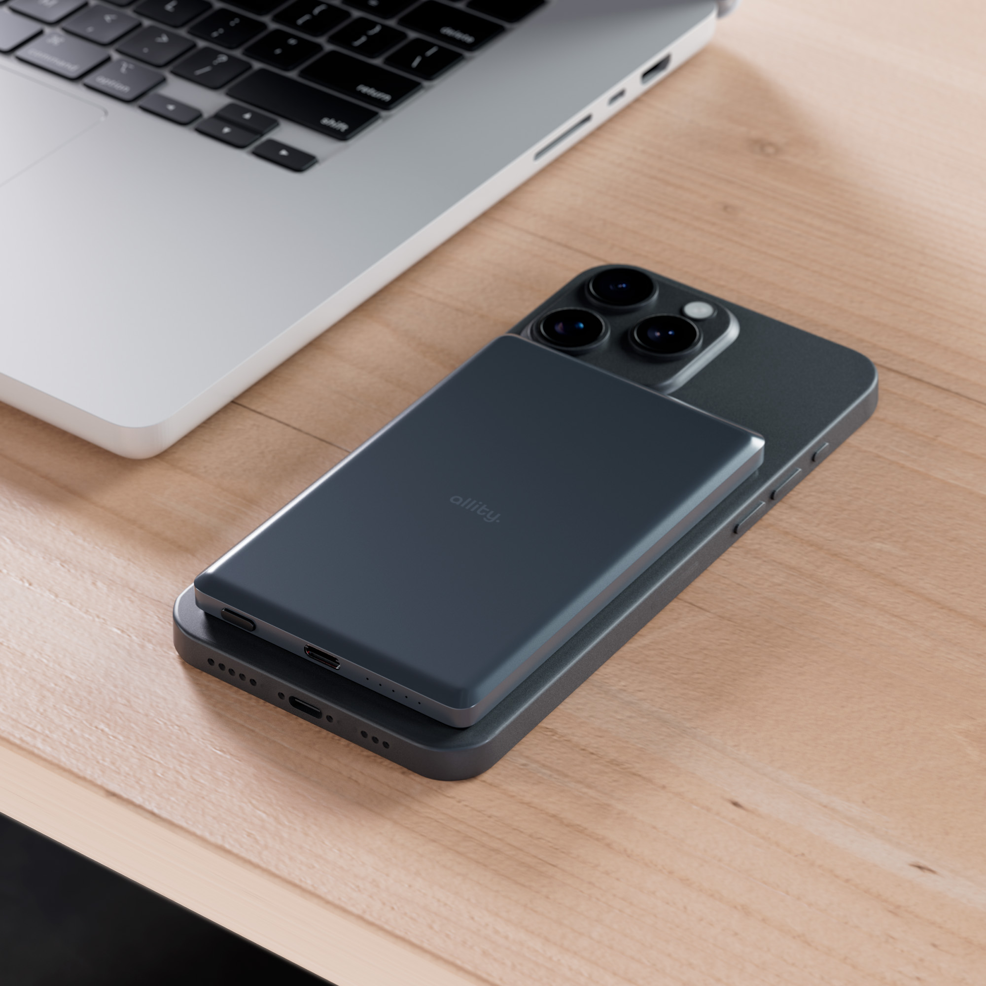 Laptop i telefon na drewnianej powierzchni. Power bank jest na górze telefonu. Tekst: allity.