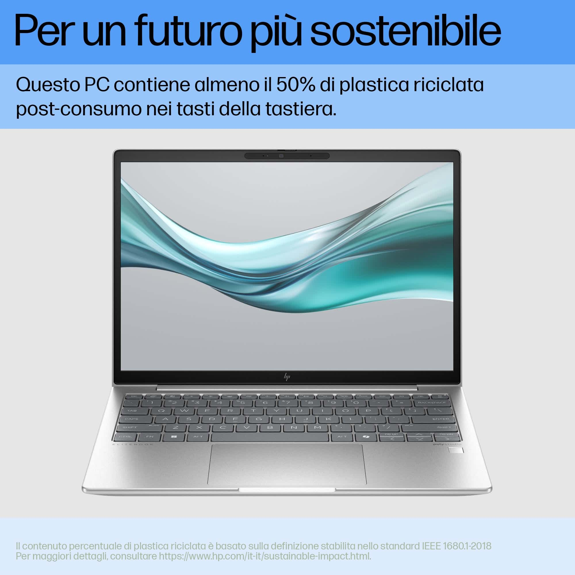 Un laptop argentato con tastiera è aperto. Lo schermo mostra un'immagine astratta sfocata.