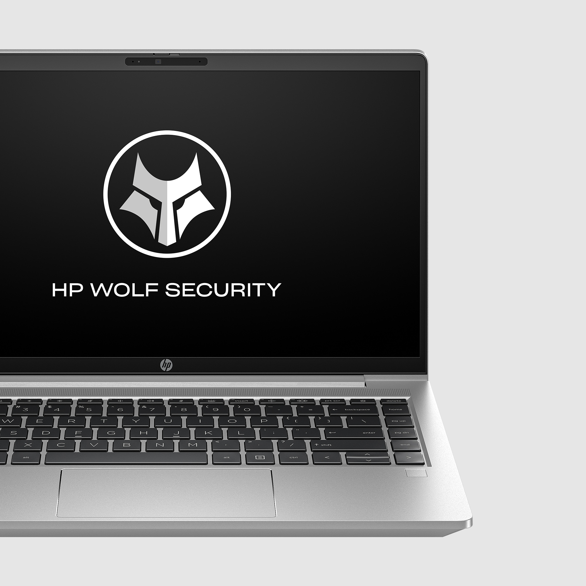 Lo schermo del laptop visualizza il logo HP WOLF SECURITY. Il laptop è argentato e su una superficie grigia.