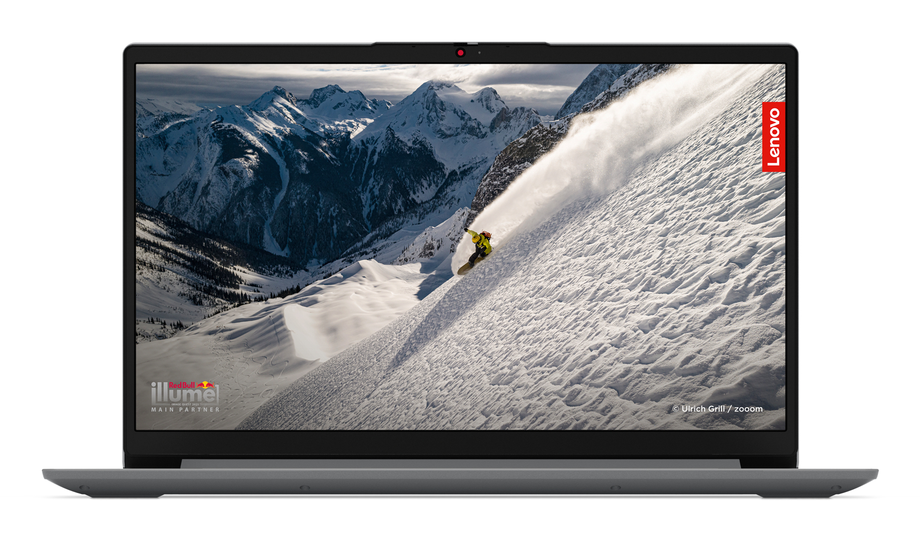 Laptop Lenovo pokazujący narciarza na zaśnieżonej górze. Widoczne logo Red Bull i illume.