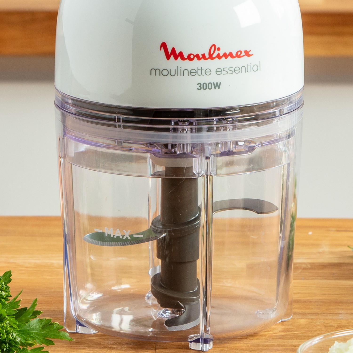 Ein weißer und transparenter Moulinex-Mixer mit schwarzer Klinge im Inneren auf einer Holzoberfläche.