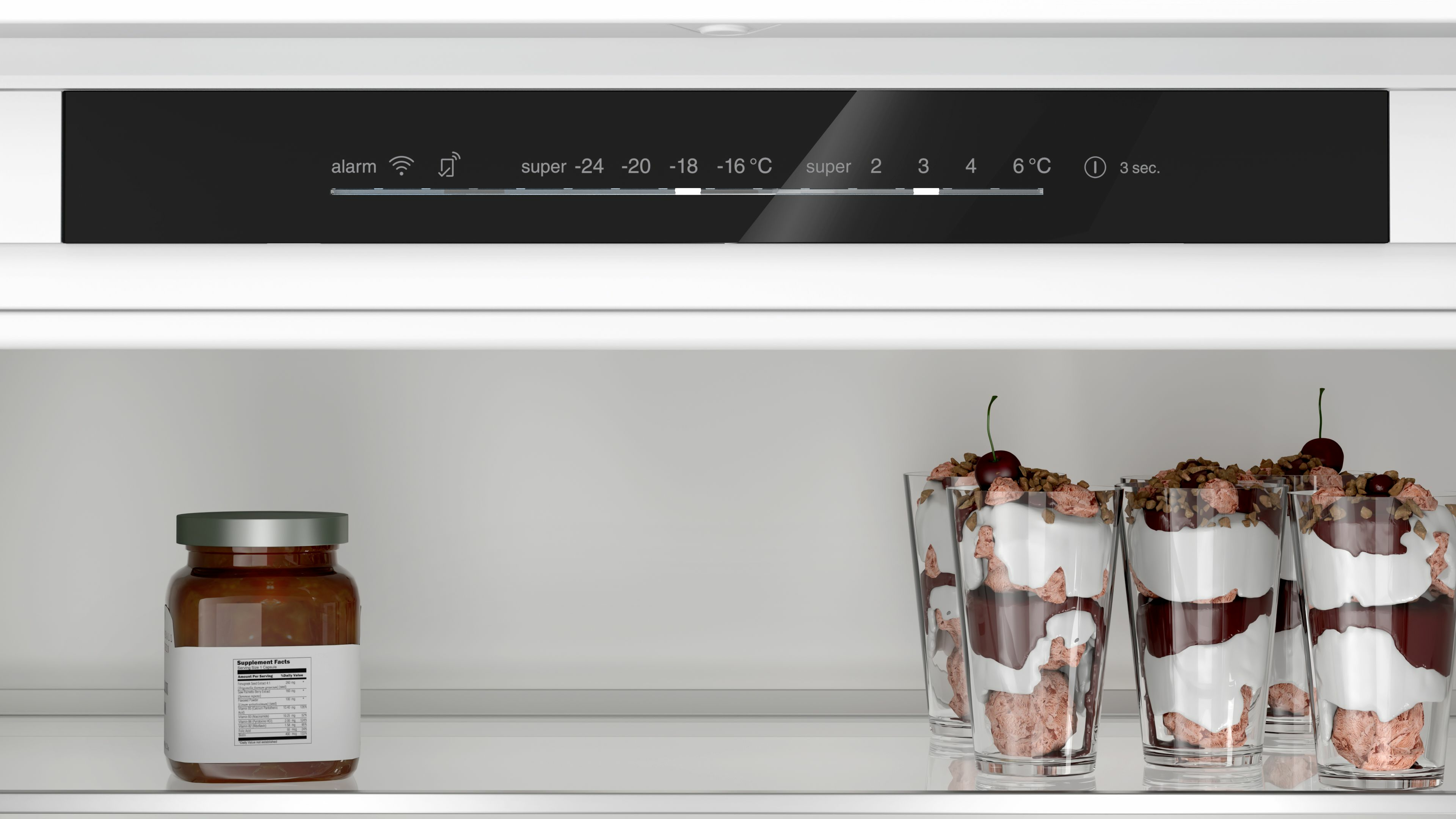 Interno frigorifero con barattolo, bicchieri da dessert e display digitale con varie impostazioni.