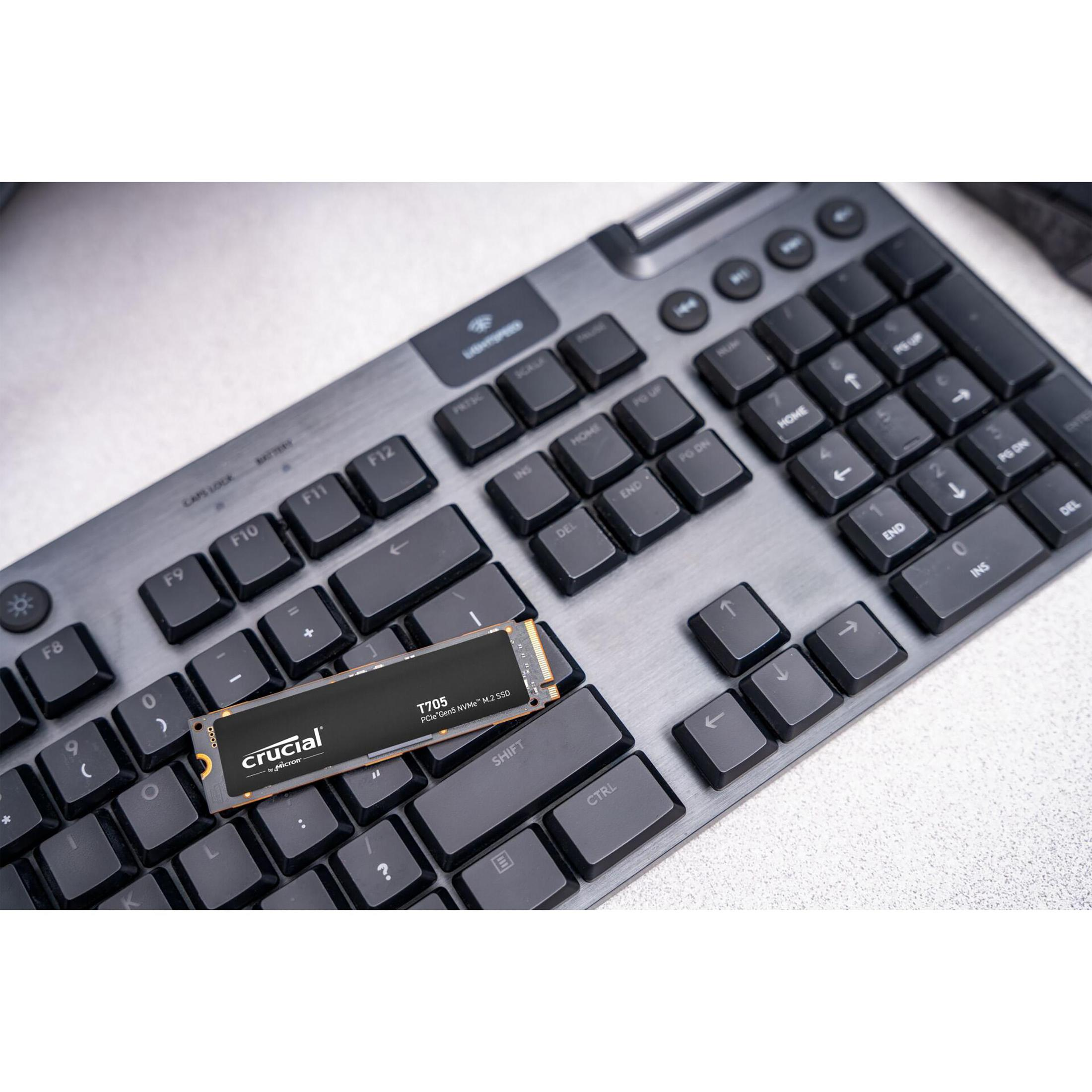 Czarna klawiatura z zainstalowanym dyskiem SSD Crucial na klawiszach.