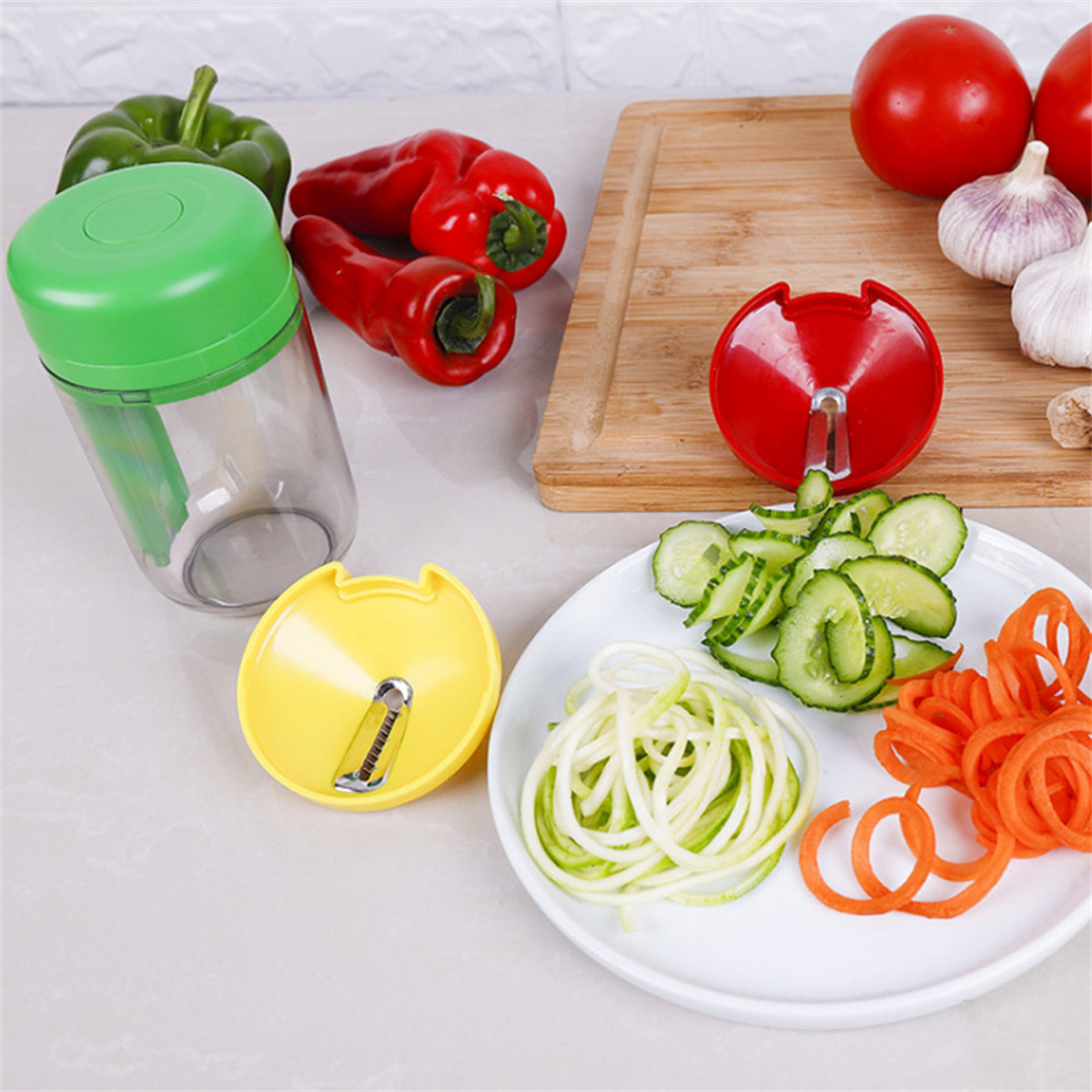 Gemüse-Spiralschneider mit Gemüse: Gurkennudeln, Karottenspiralen, Paprika und Tomaten.