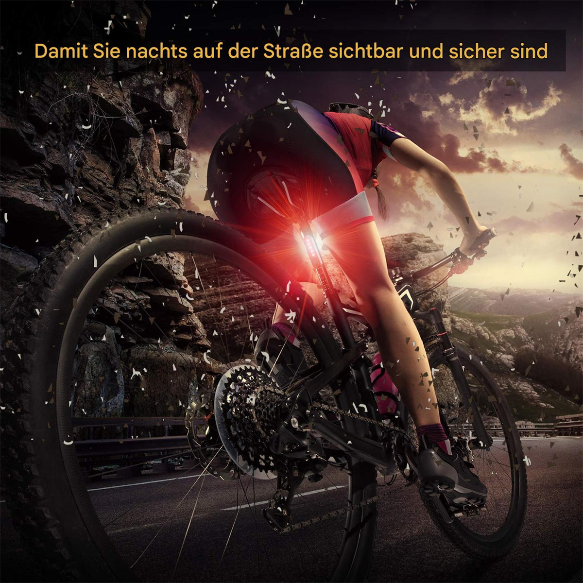 Ein Radfahrer fährt nachts mit sichtbarem rotem Licht Fahrrad. Im Hintergrund eine Berglandschaft.