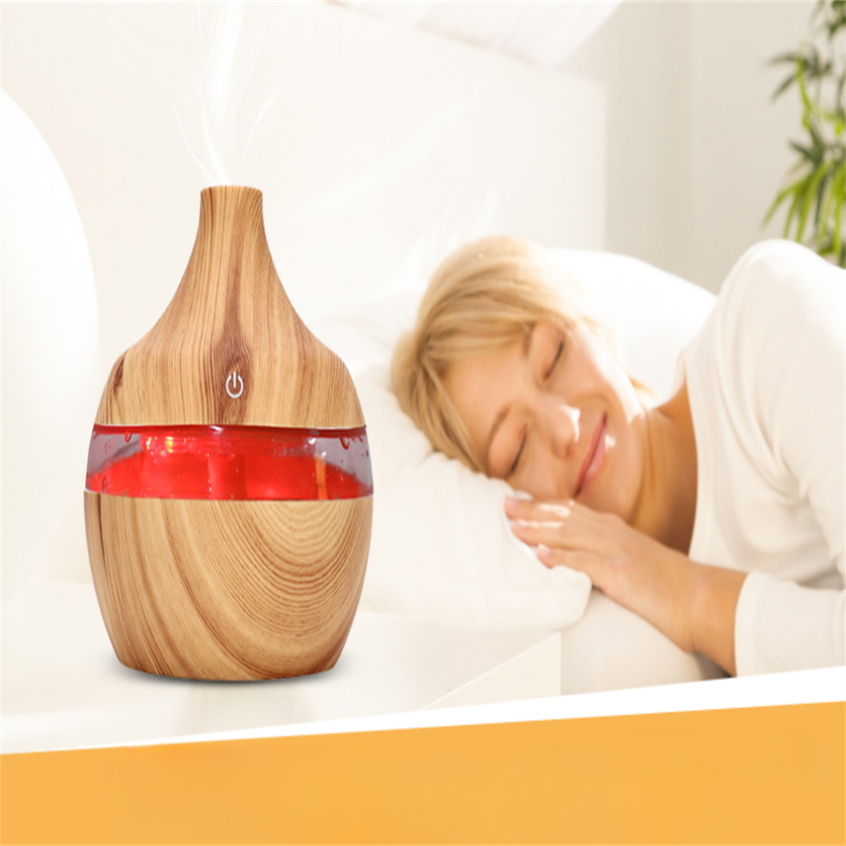 Holz-Aromadiffusor mit rotem Licht und eine schlafende Frau in einem weißen Bett.