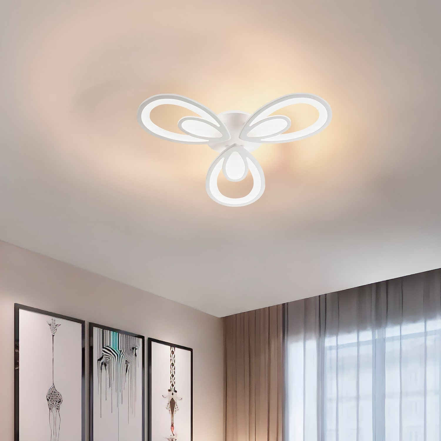 Lampada da soffitto bianca con tre forme curve a petalo attorno a una sorgente luminosa centrale.
