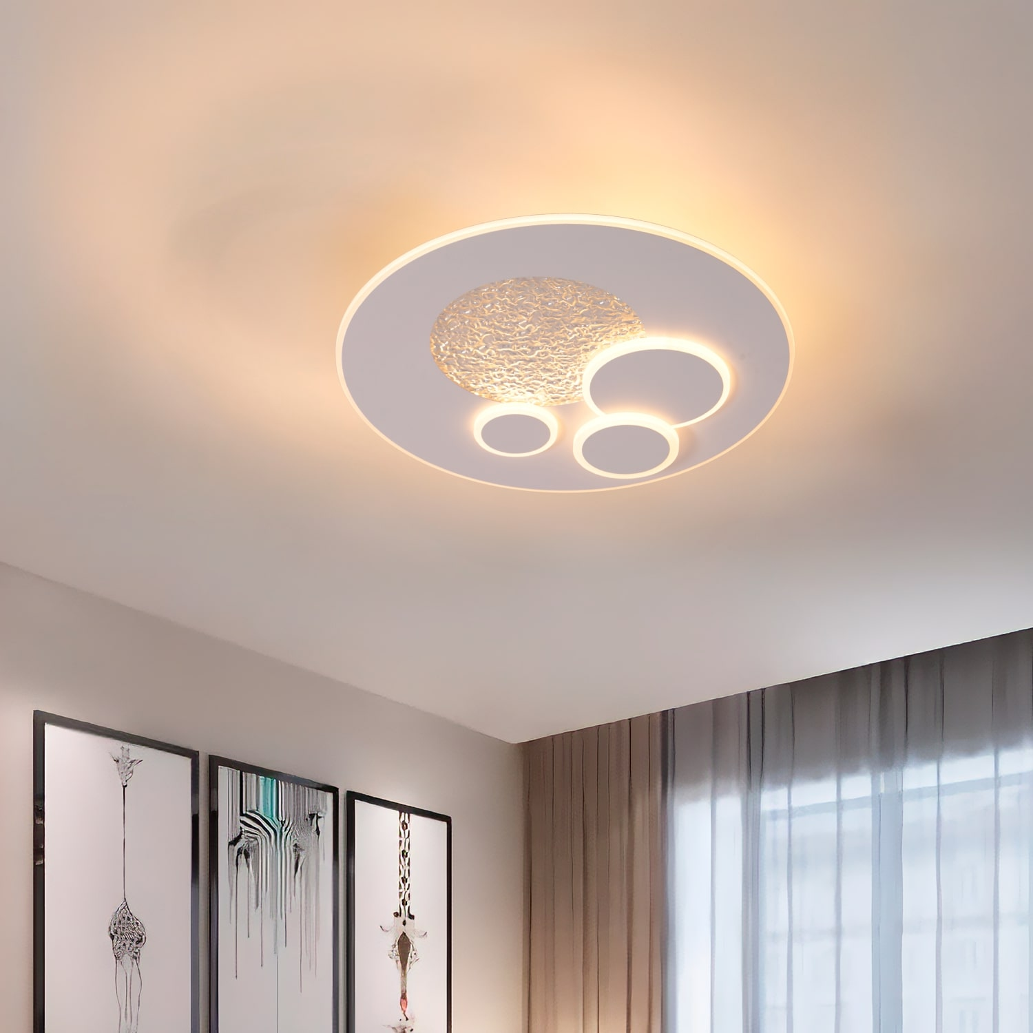 Lampada da soffitto in una stanza con arte. La luce è bianca e la stanza ha tende grigie.