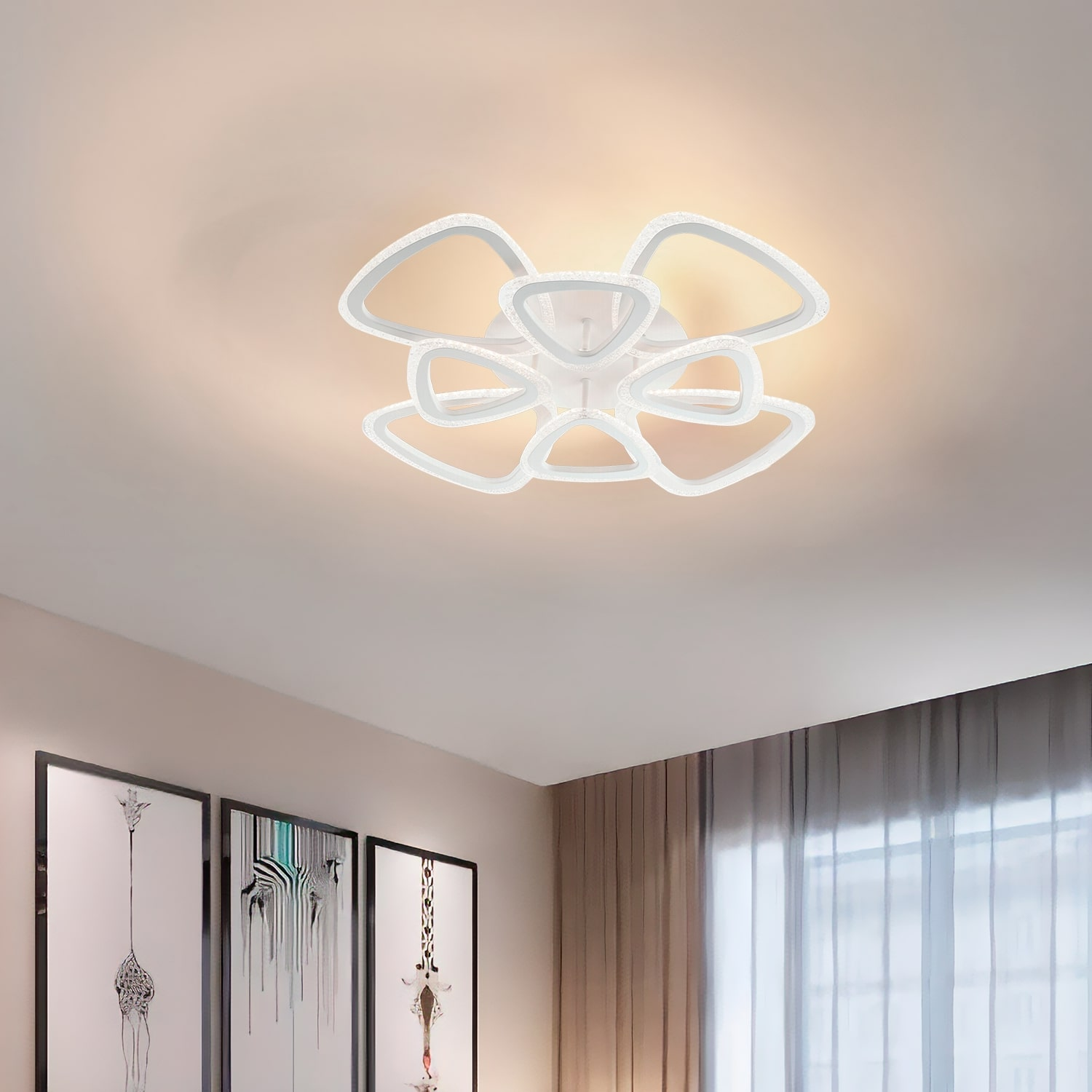 Lampada da soffitto in una stanza con arte. La luce è bianca e la stanza ha tende grigie.