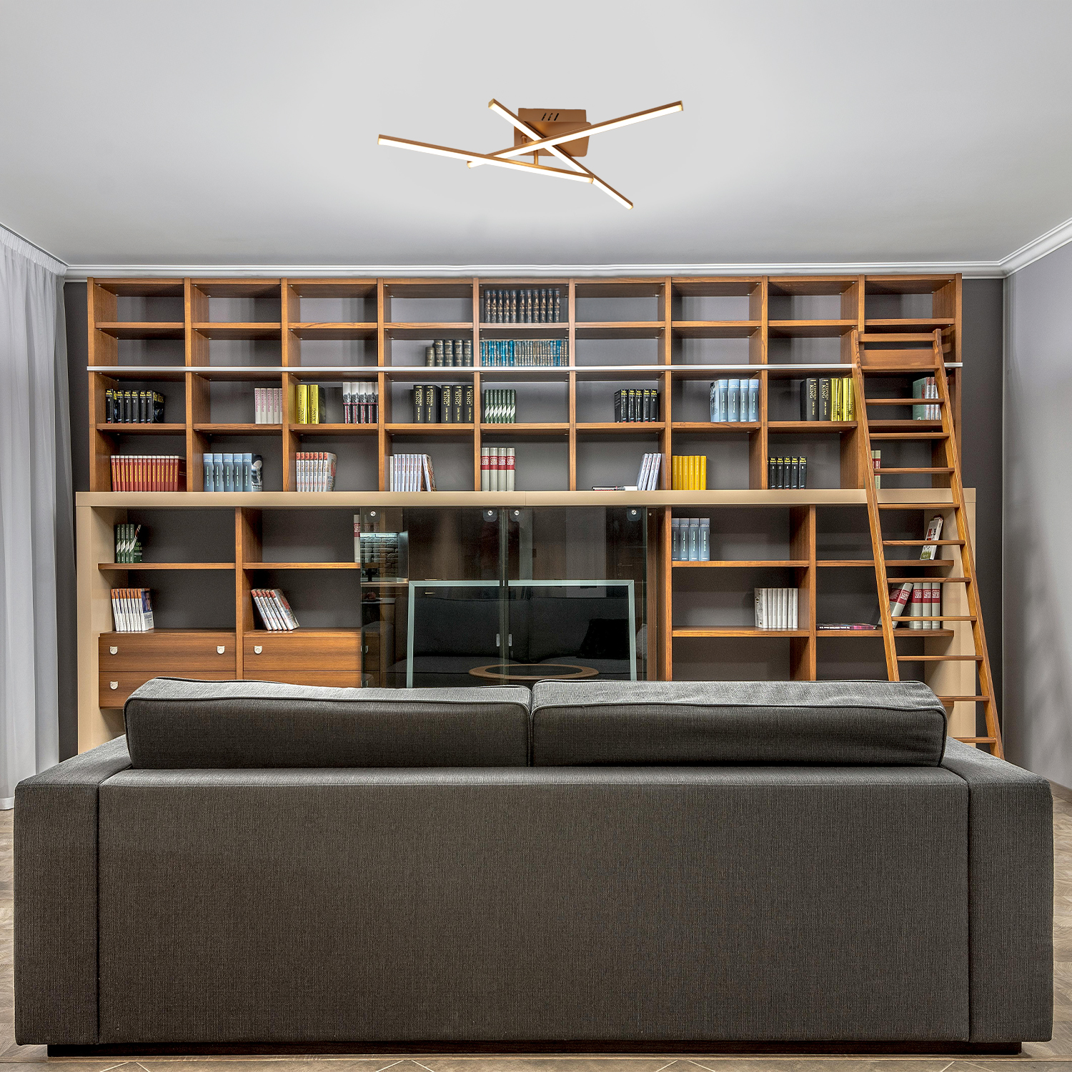 Una stanza con una libreria in legno, un divano e una lampada da soffitto. La lampada ha un design lineare, colore bianco.