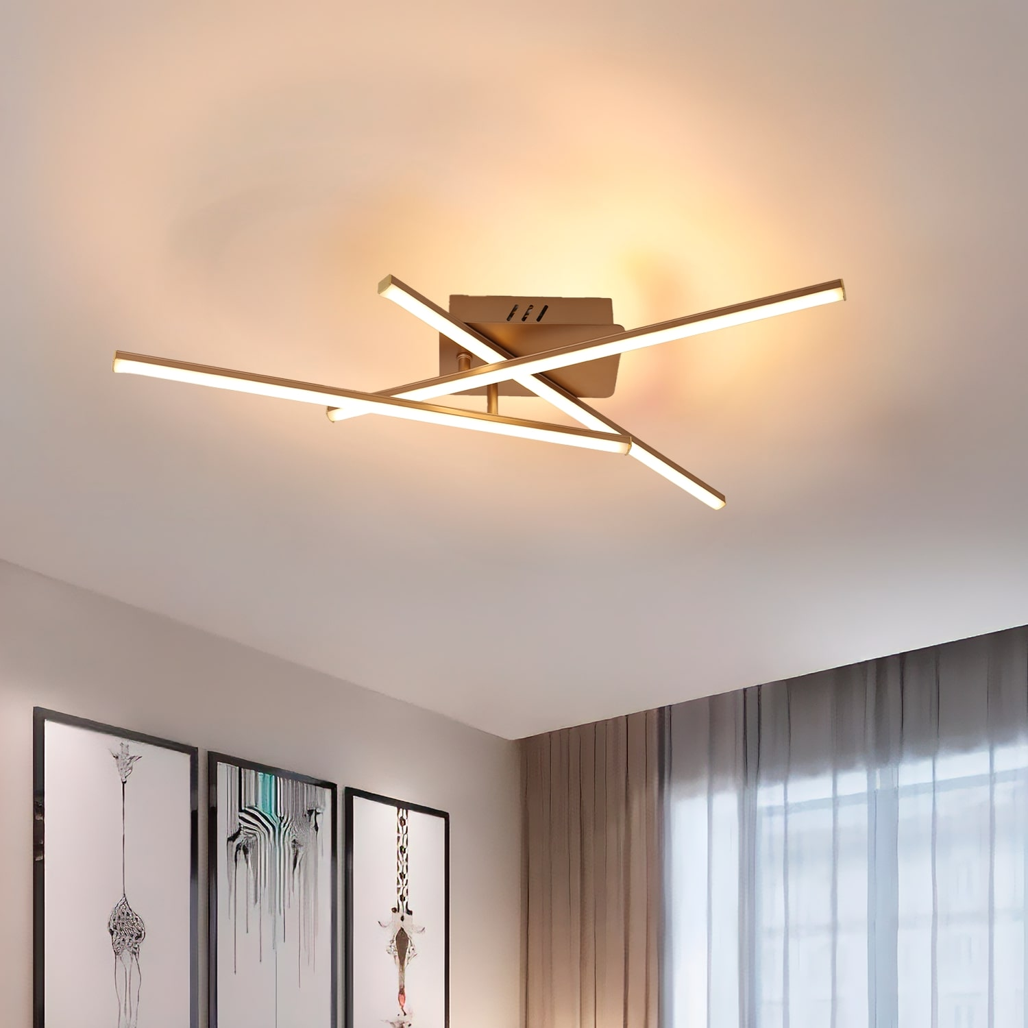 Una plafoniera con barre luminose intersecanti. Sotto, quadri e una tenda.