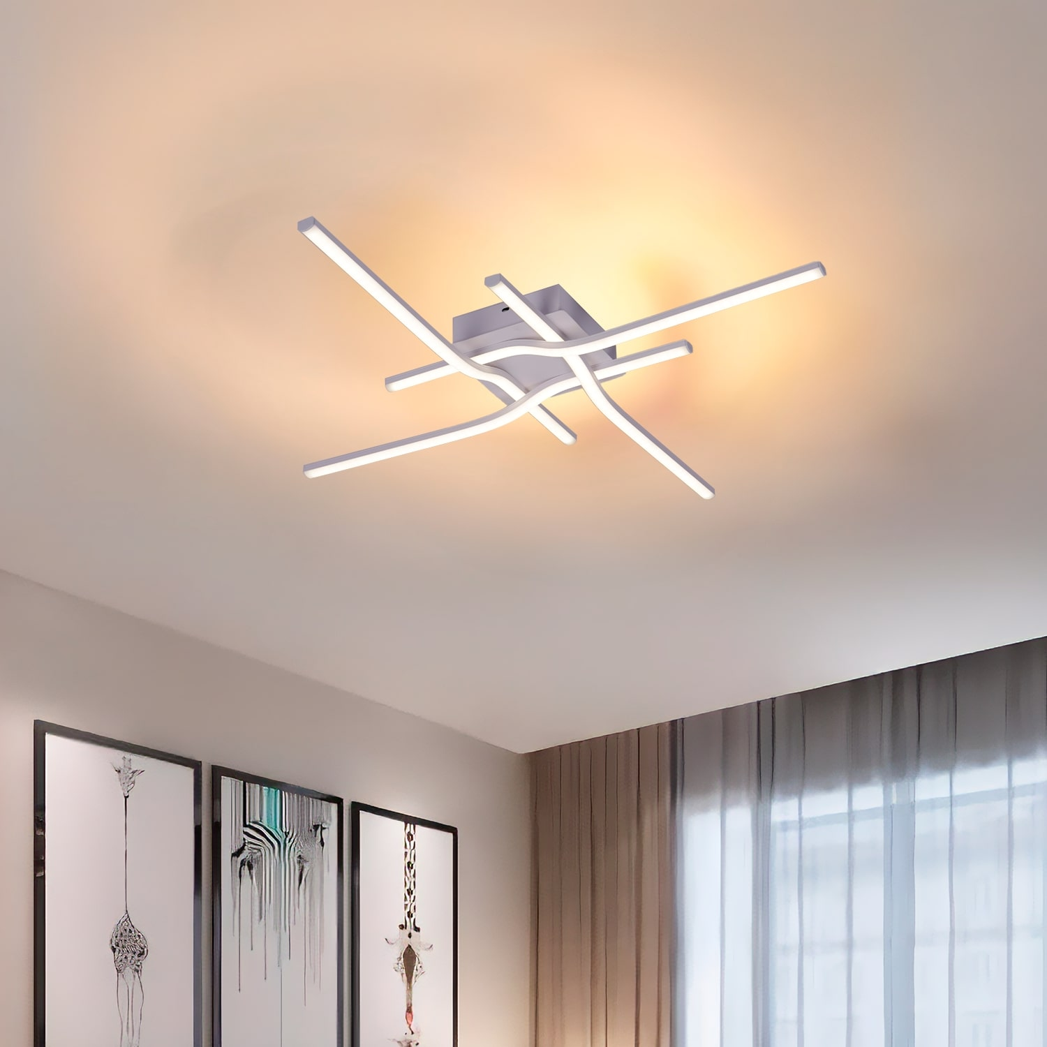 Una lampada da soffitto con un design a forma di croce è centrata. Lo sfondo include un soffitto bianco e opere d'arte.