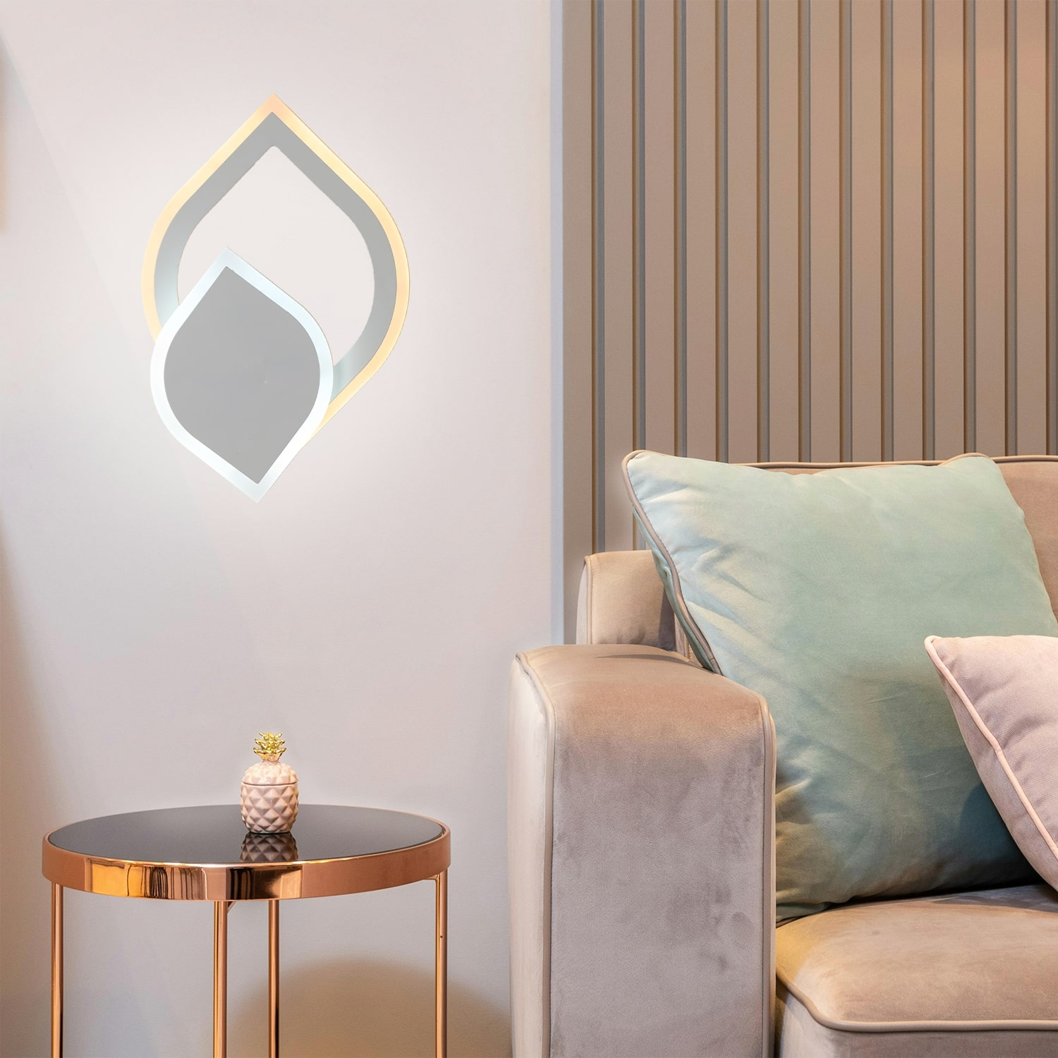 Lampada da parete moderna, design oro e bianco, tavolo con ananas, divano nella stanza.