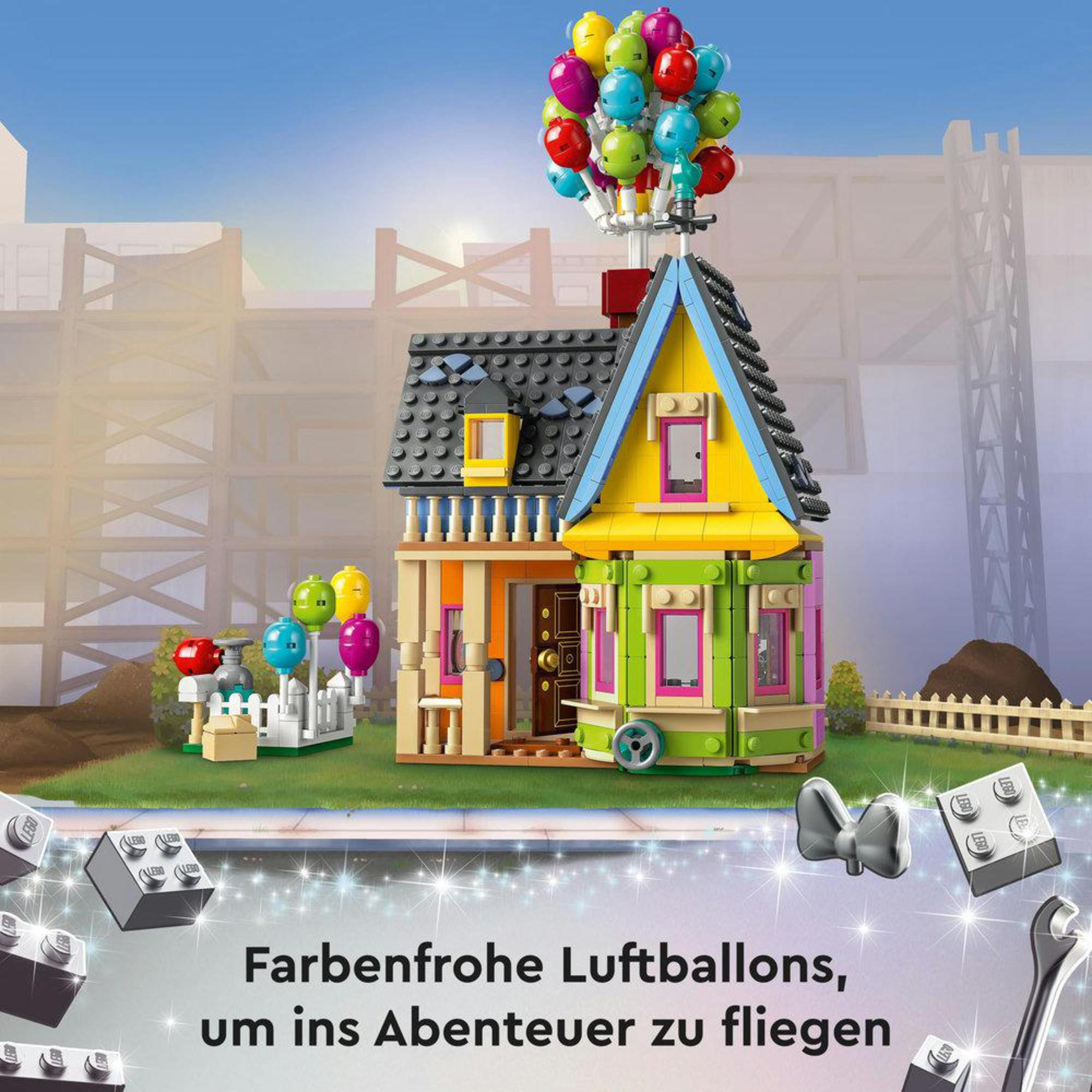 Casa Lego con palloncini, recinzione bianca e sfondo costruzione. Testo in tedesco.
