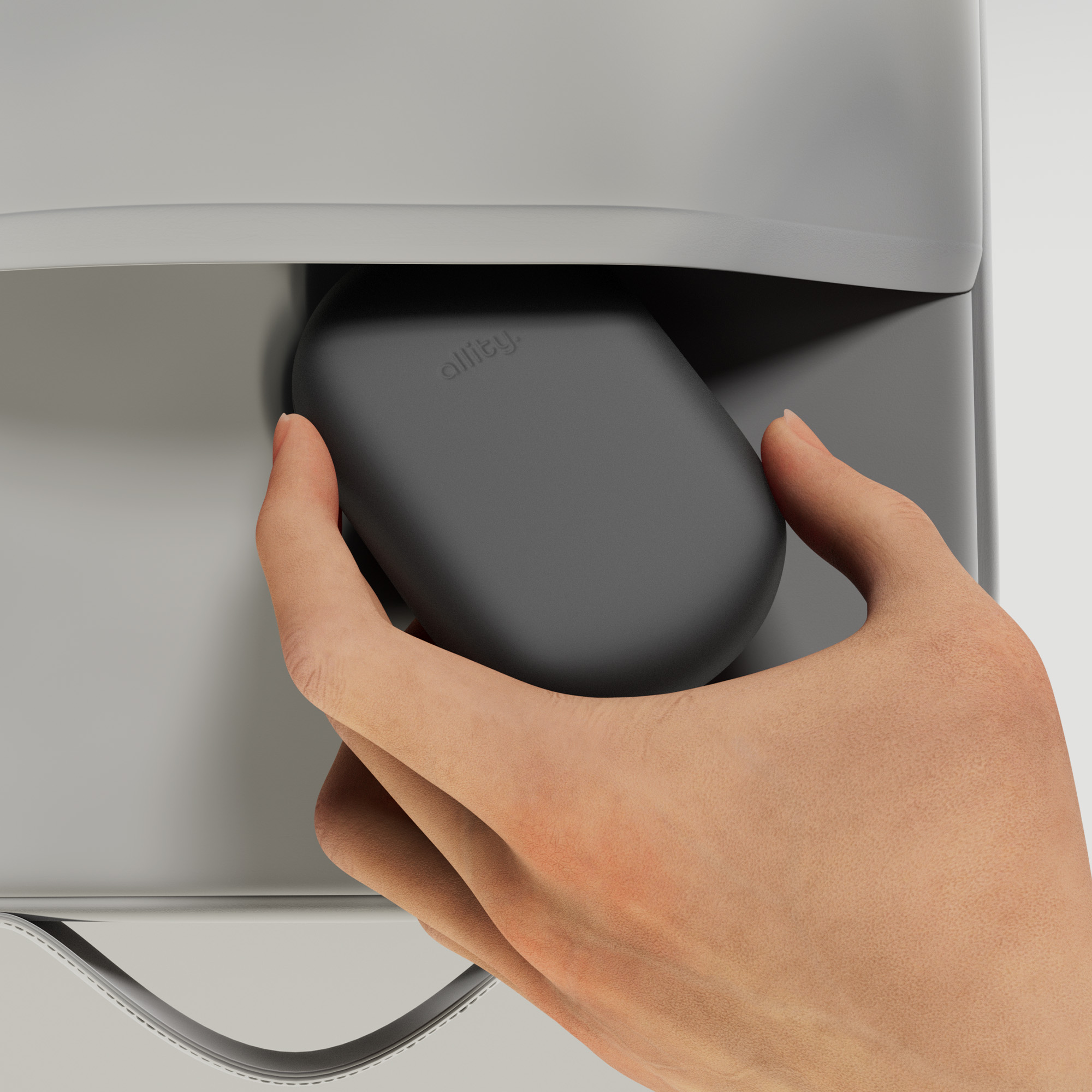 Mano che tiene una custodia ovale grigio scuro, vicino a una superficie grigia.