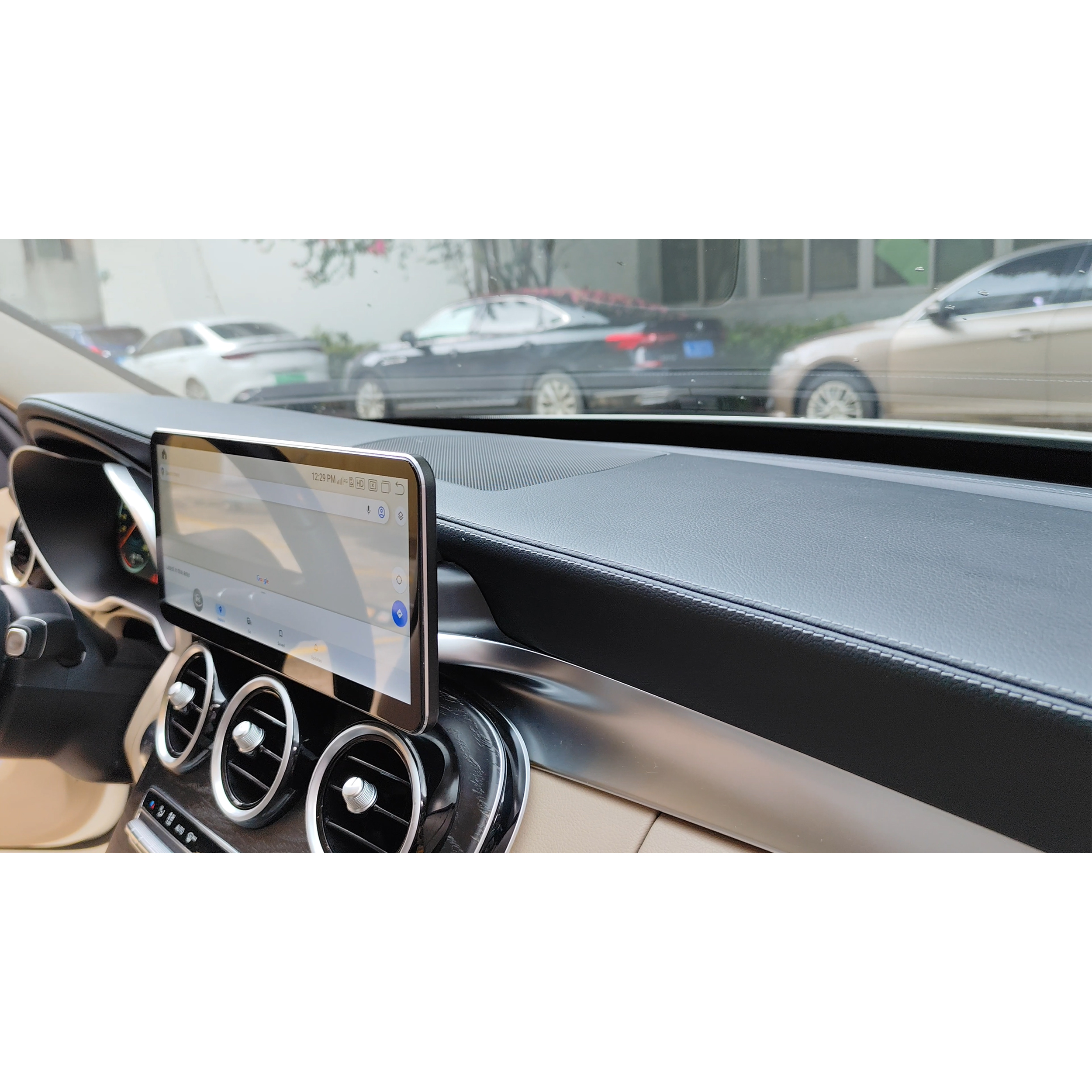 Tablet auf dem Armaturenbrett eines Autos montiert, zeigt eine Benutzeroberfläche. Innenraum des Autos im Hintergrund.