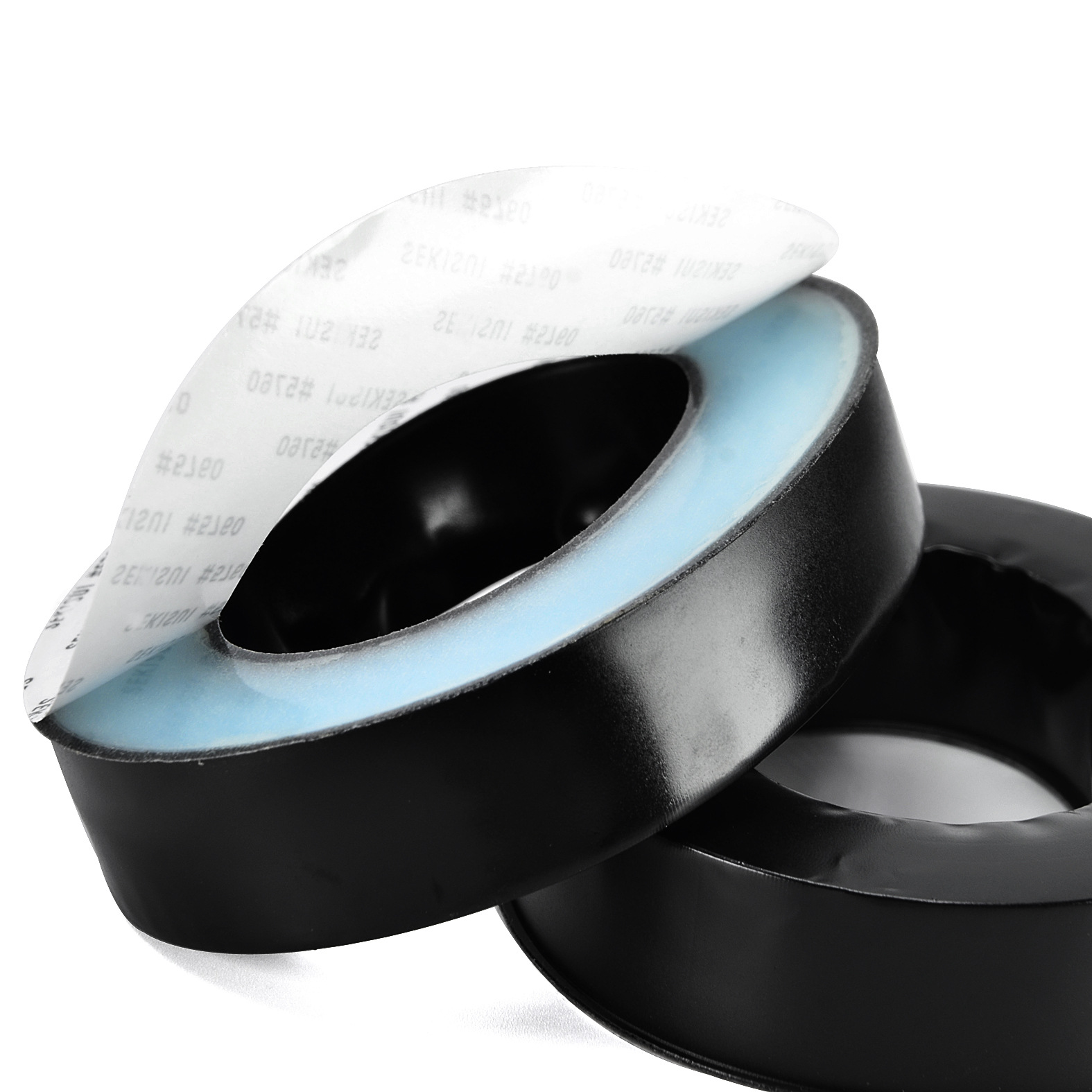 Dwie czarne, okrągłe podkładki samoprzylepne z niebieskim środkiem. Jedna podkładka jest otwarta, odsłaniając klej.