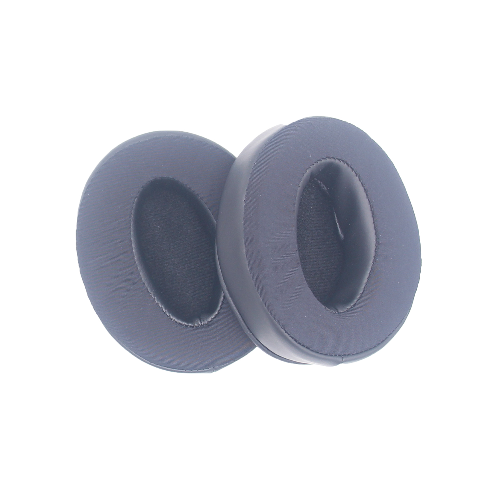 Dwie czarne poduszki na uszy, okrągłe, na białym tle. Materiał piankowy.