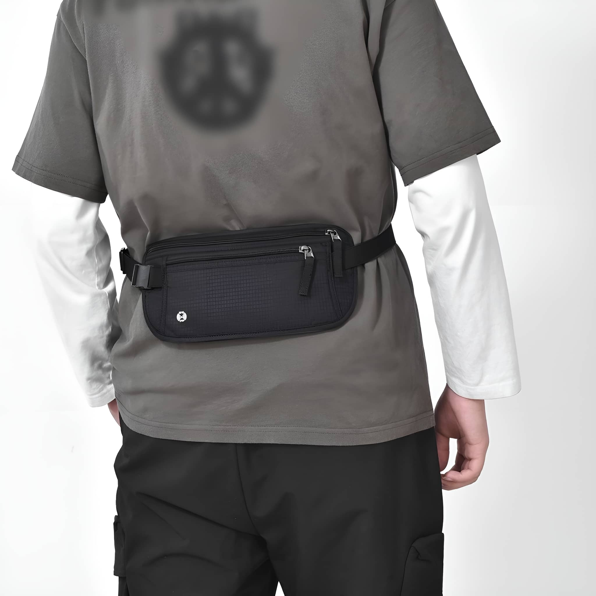 Person mit Bauchtasche, von hinten gesehen. Trägt graues Hemd und schwarze Hose.